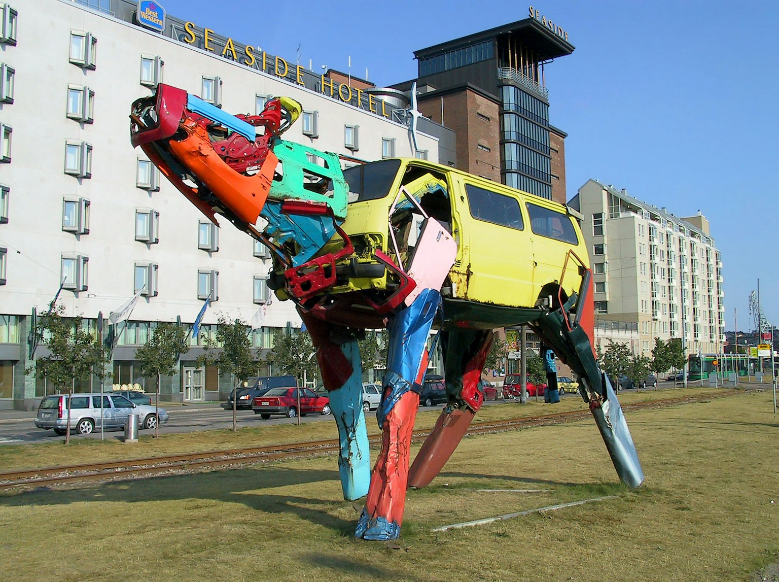 Sculpture de robot coloré ressemblant à un chien faite de pièces de voiture