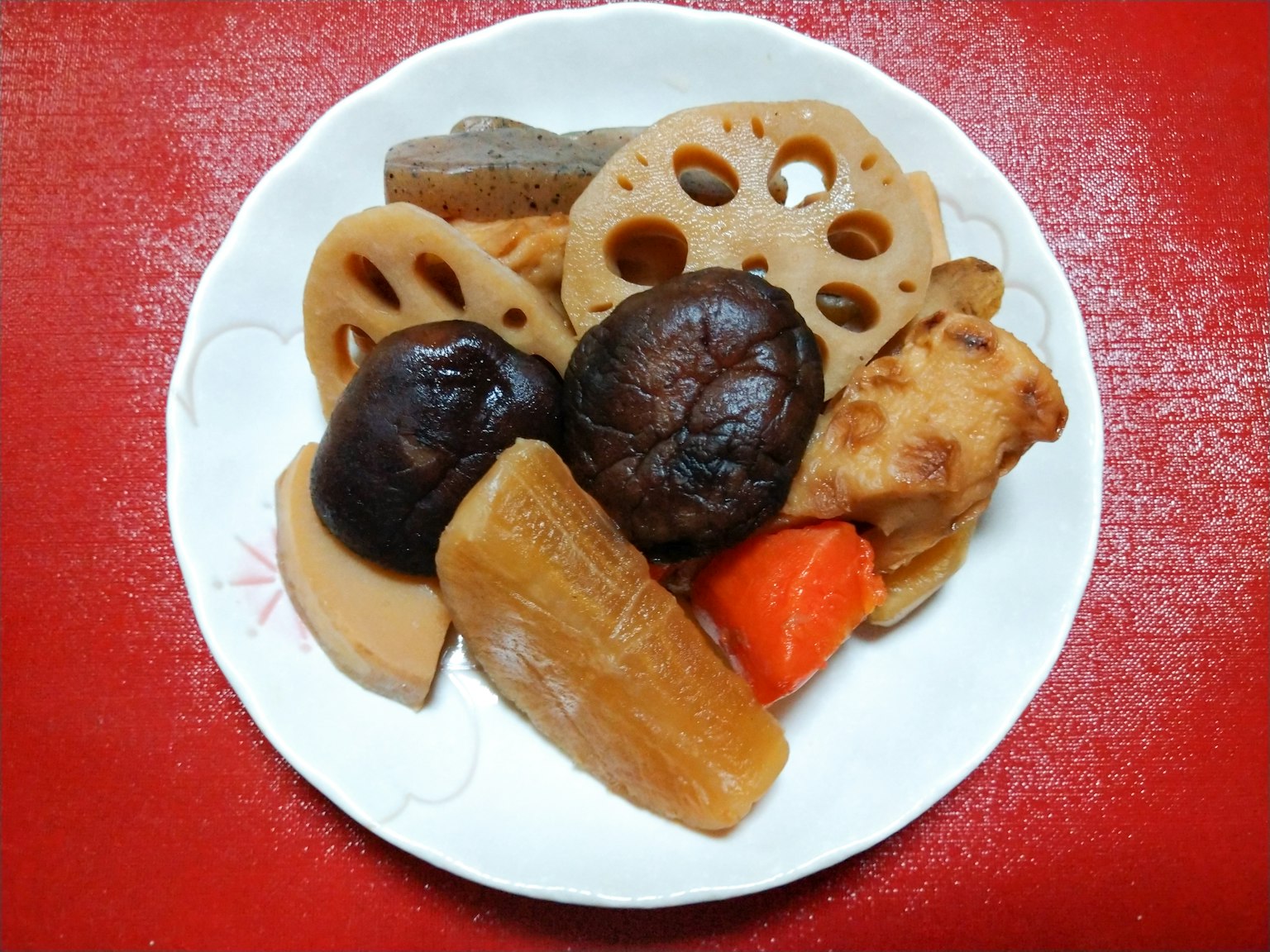 白色盘子里的各种炖菜在红色背景下