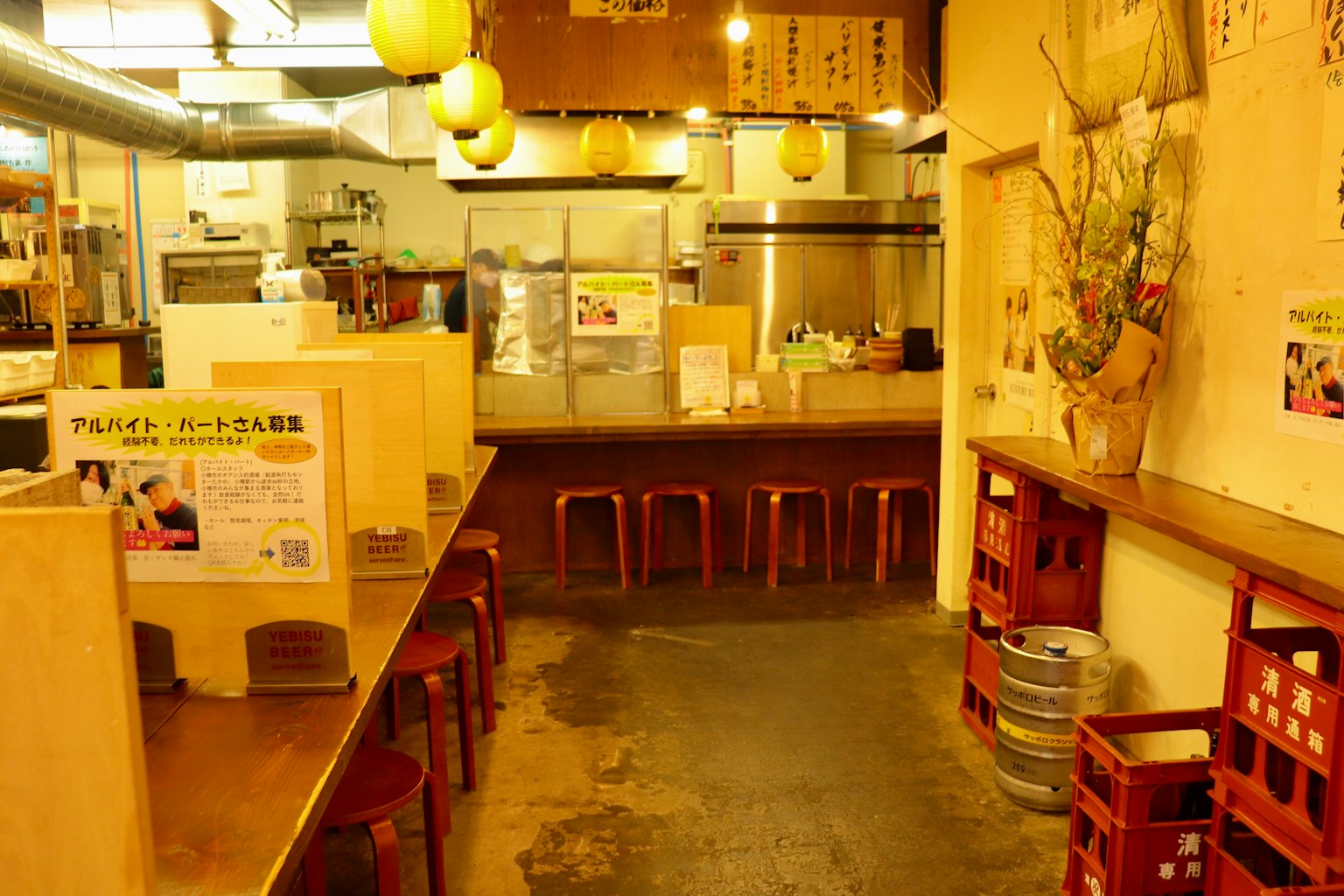 Interior izakaya meja kayu dan kursi area dapur terlihat pencahayaan hangat
