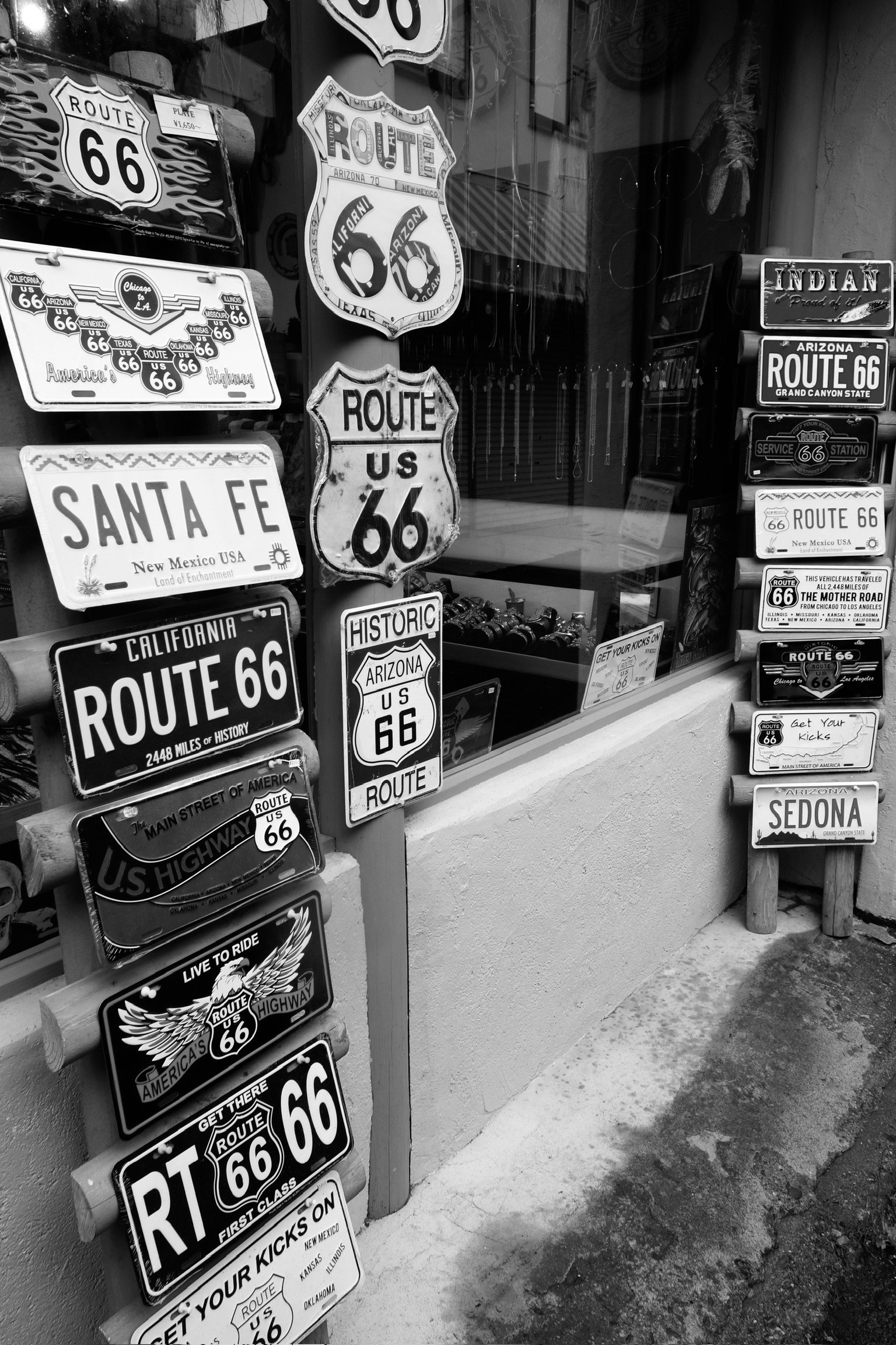 Black and white display of Route 66 license plates and Santa Fe sign