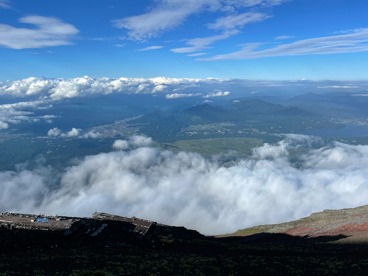 Vue panoramique depuis un sommet de montagne avec des nuages et un ciel bleu