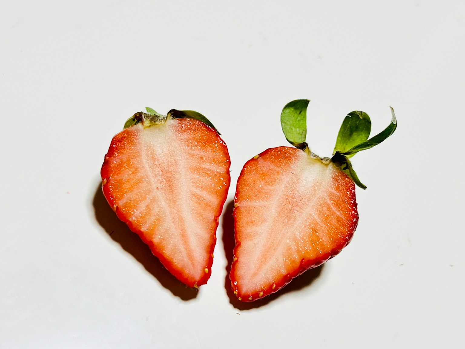 Fresas frescas en rodajas que muestran pulpa roja vibrante y hojas verdes