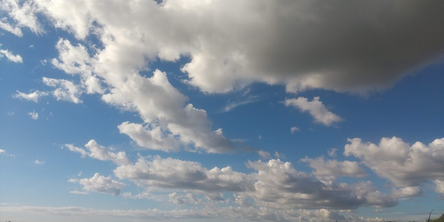 Un paisaje con cielo azul y nubes blancas