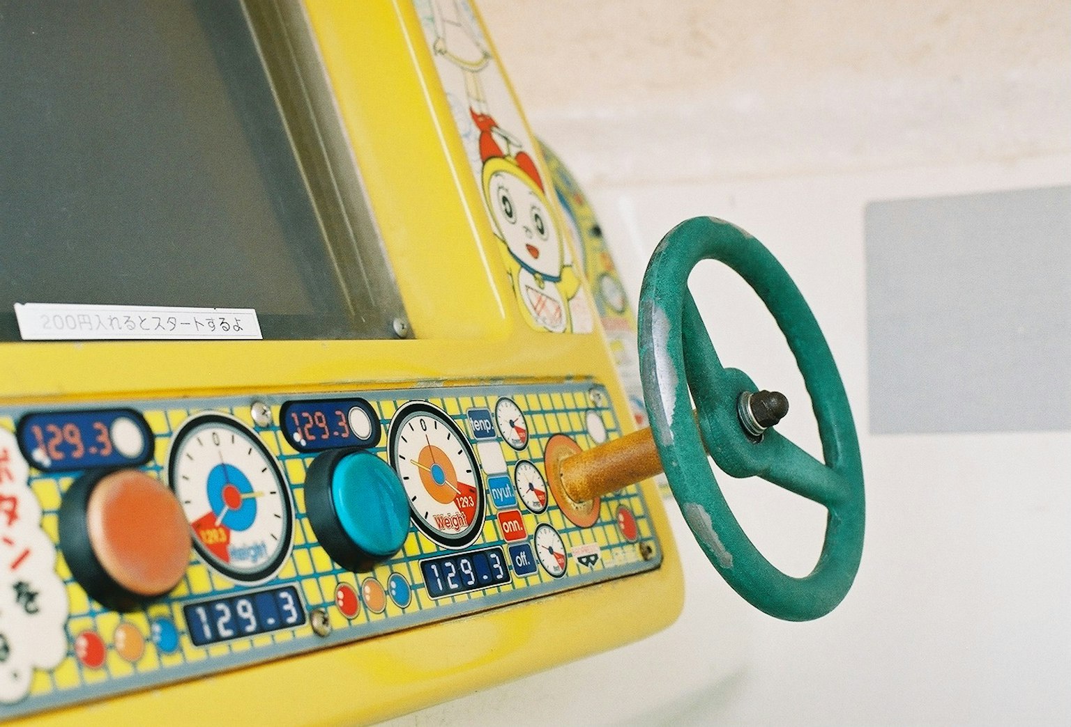 Panneau de contrôle de machine jaune coloré avec un volant vert et divers boutons