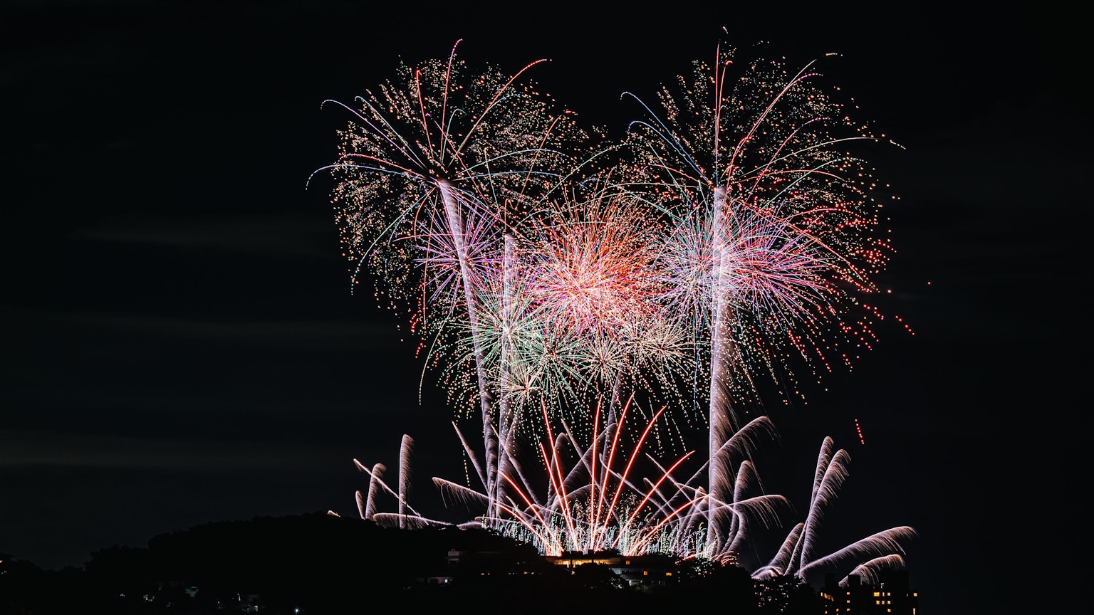 Un hermoso espectáculo de fuegos artificiales iluminando el cielo nocturno chispas coloridas estallando
