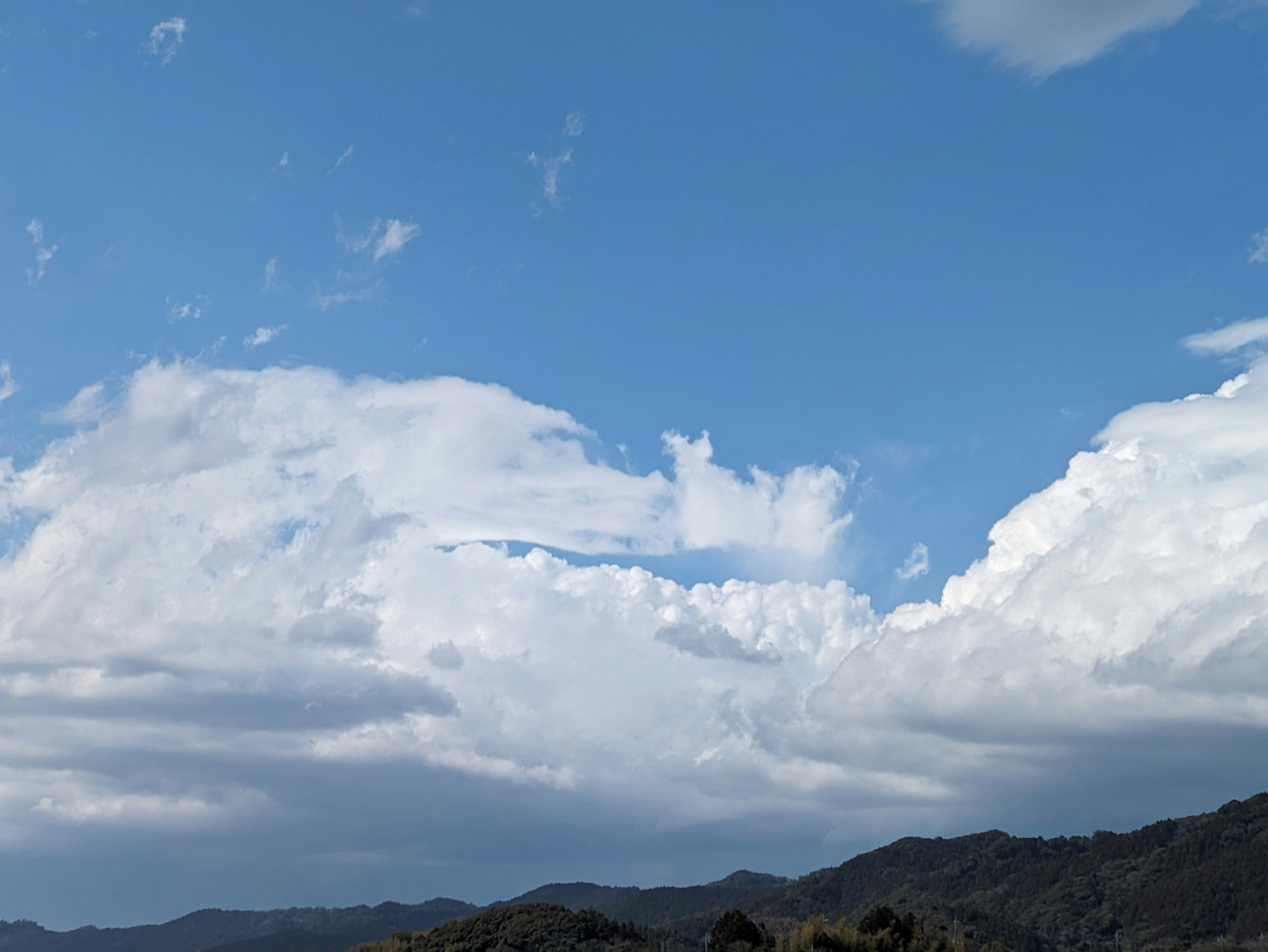 藍天與雲層下的山稜景色