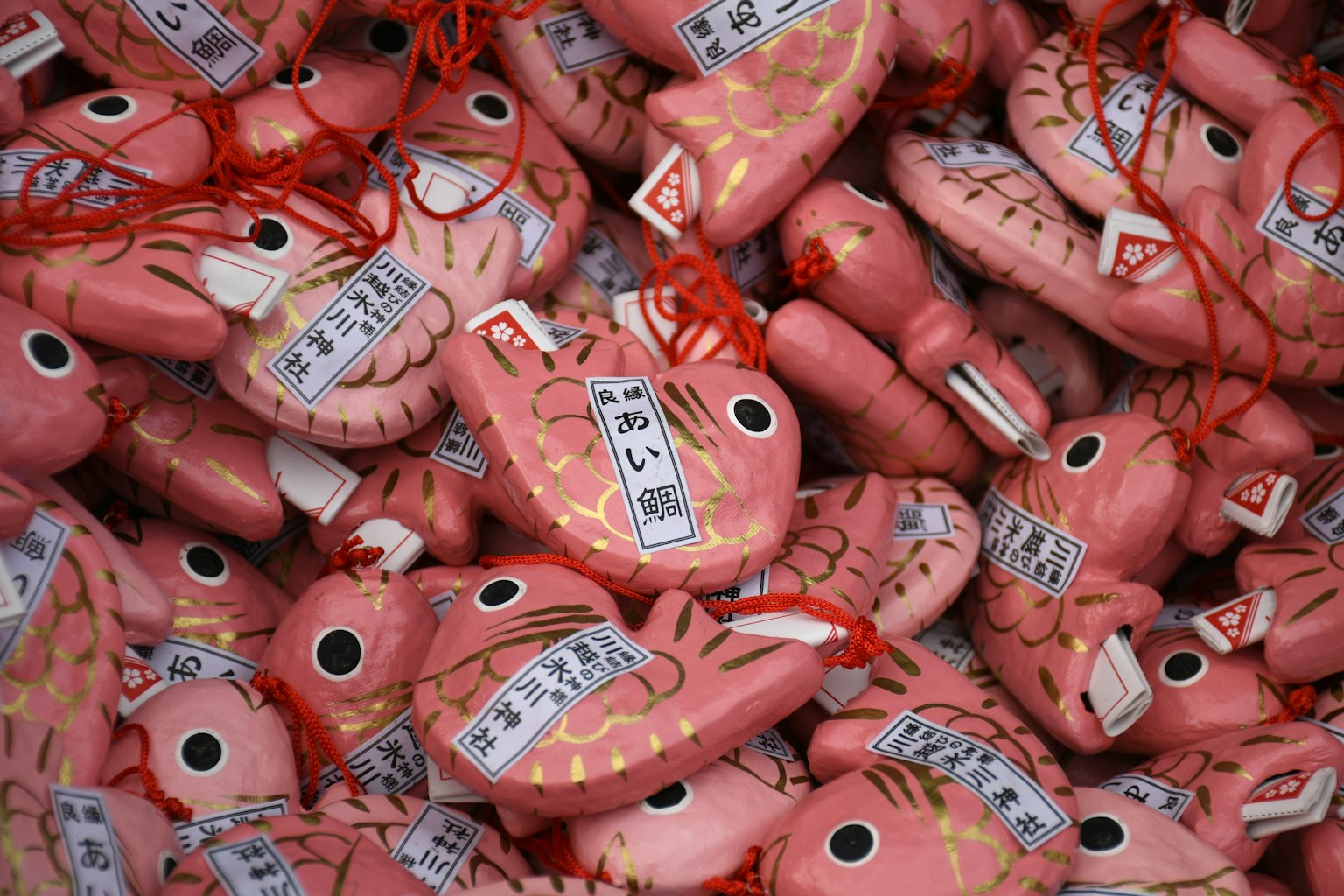 Una collezione di amuleti a forma di pesce rosa con iscrizioni