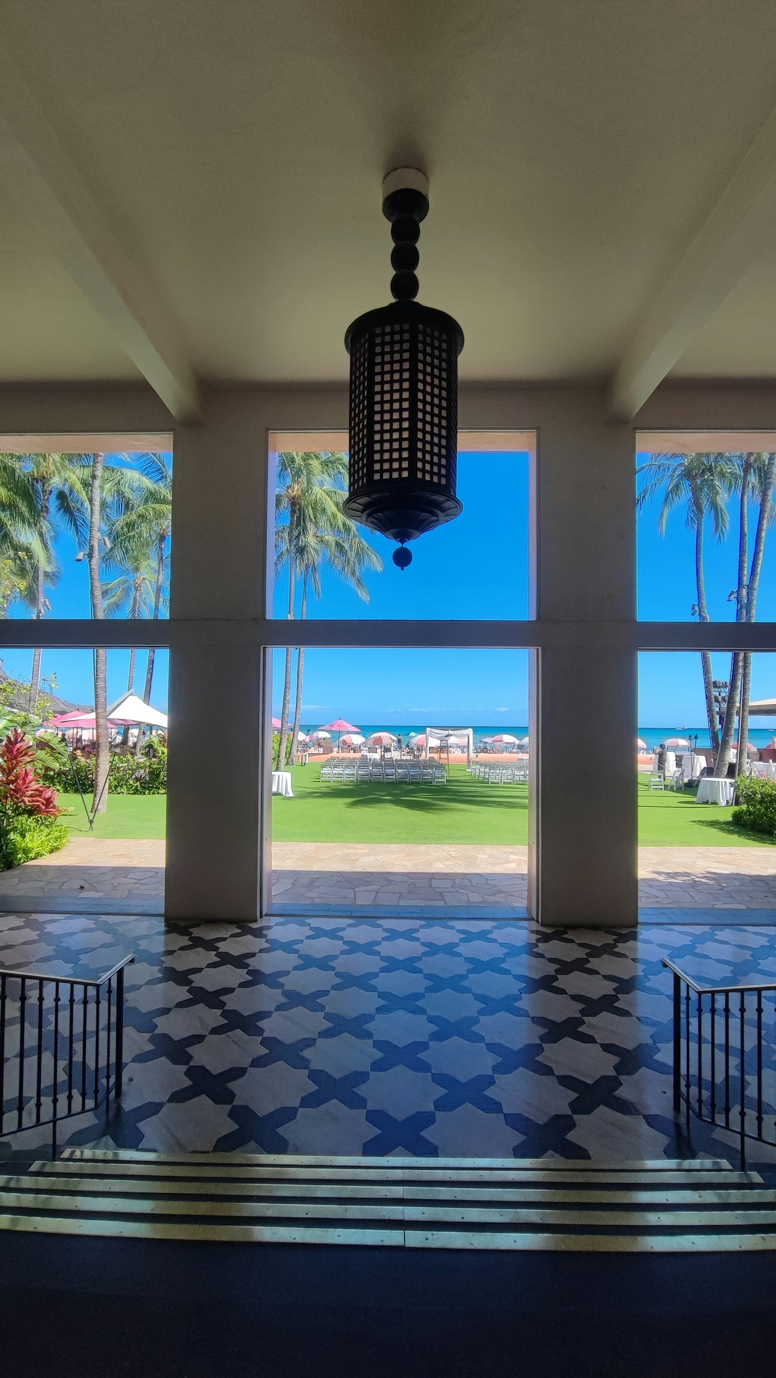 Vista di un ingresso aperto con mare e cielo blu lampadario decorativo e pavimento piastrellato