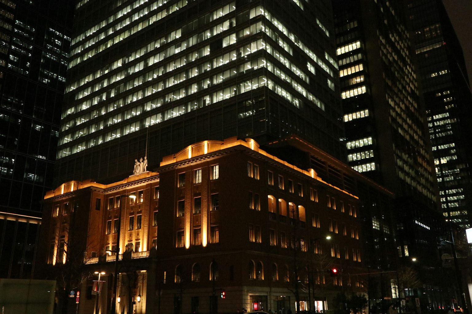 Scena notturna urbana con grattacieli moderni e un edificio storico illuminato