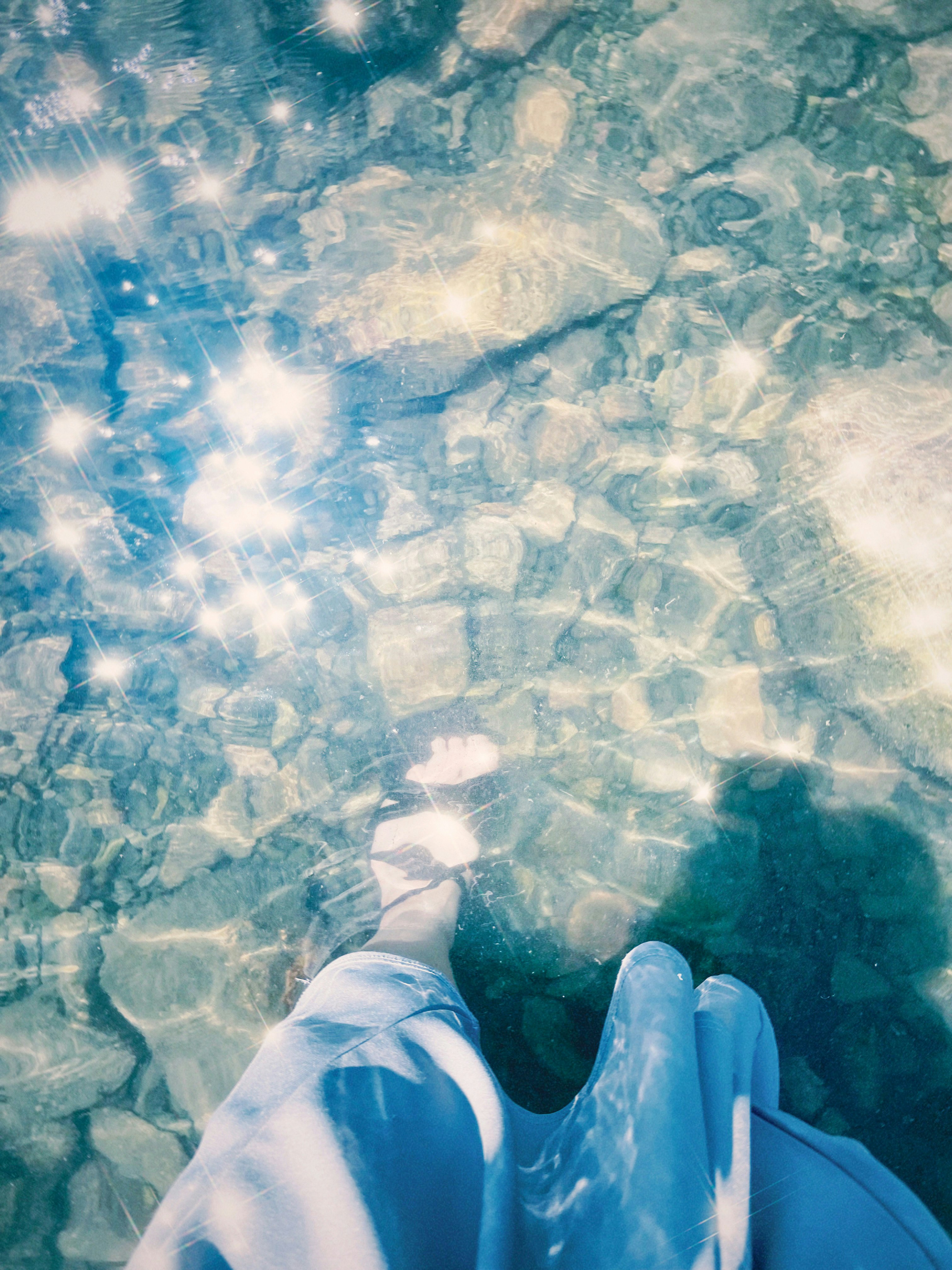 piedi che galleggiano su acqua estiva limpida