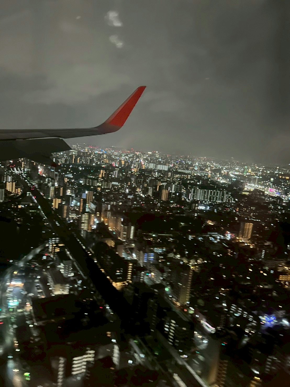夜景を見下ろす飛行機の窓からの都市の眺め
