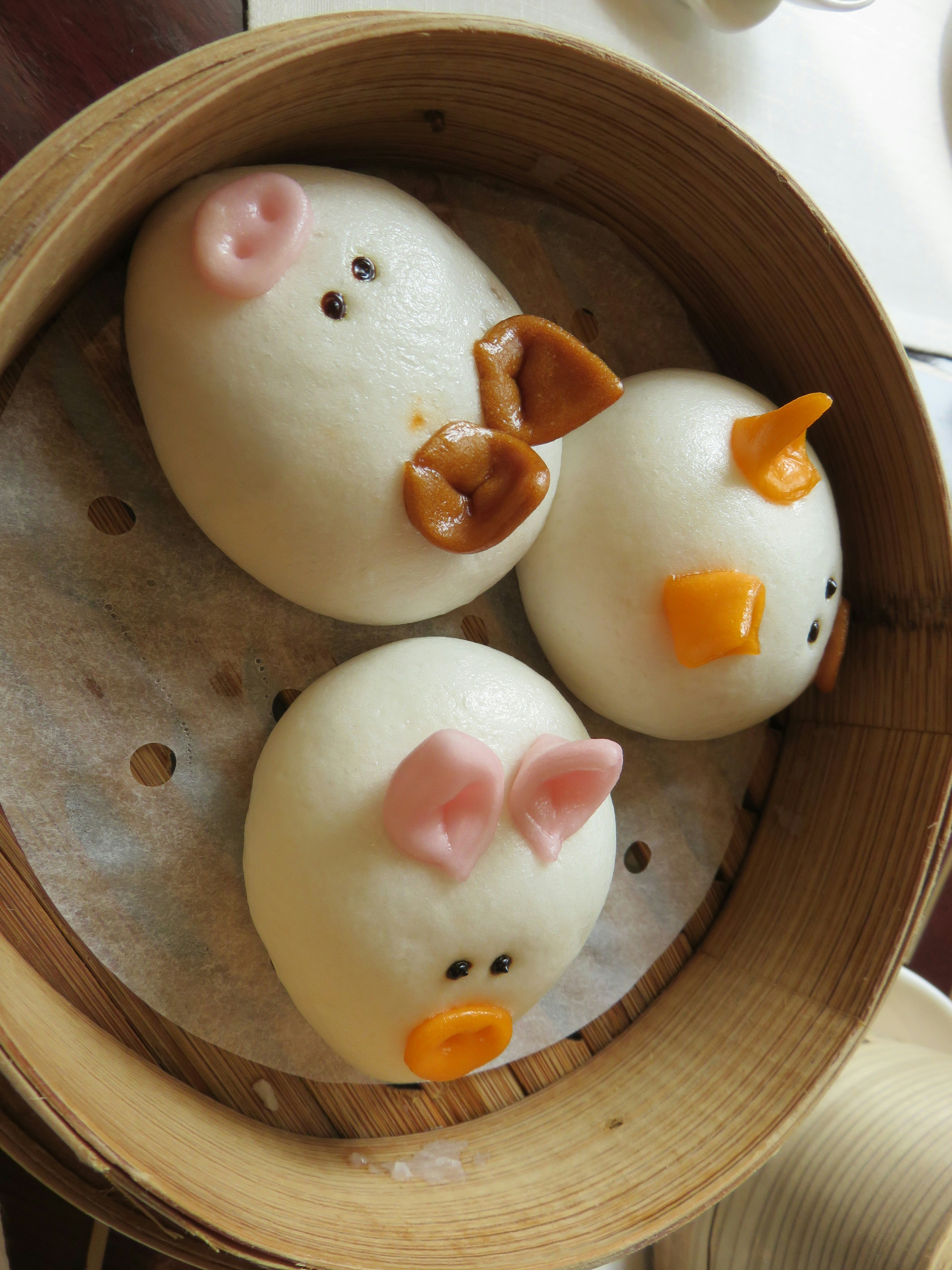 木製の器に並ぶ可愛い肉まん風の動物パン