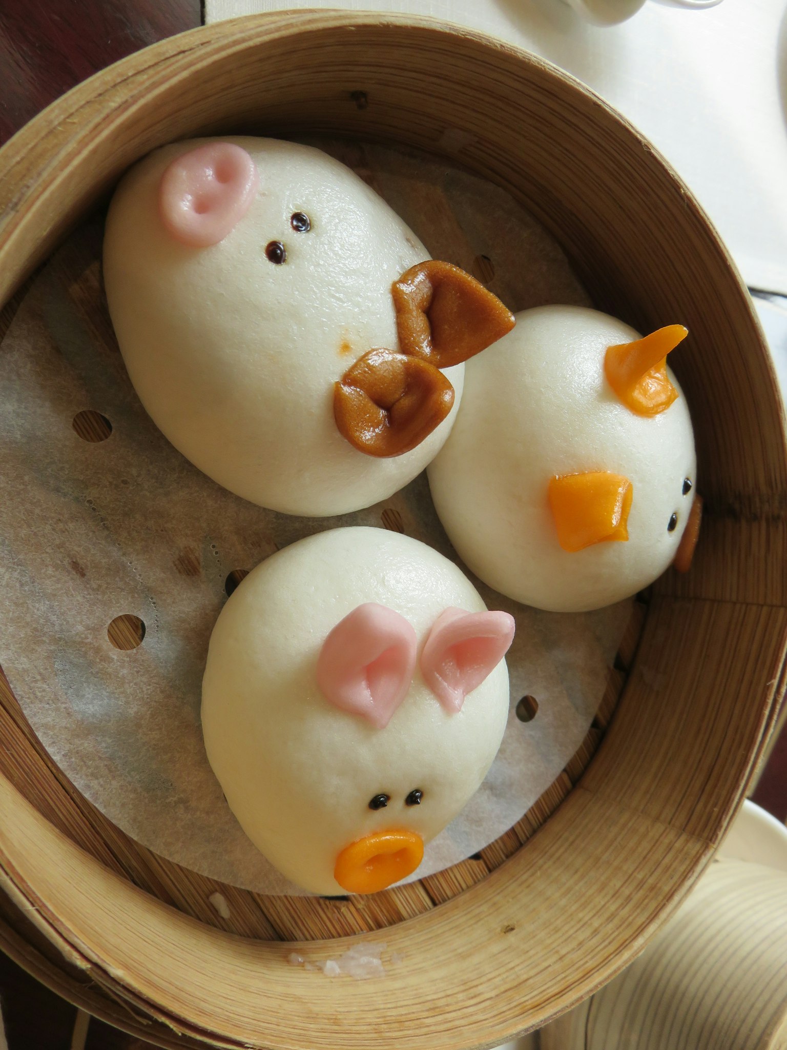 Bollos al vapor con forma de animales dispuestos en una vaporera