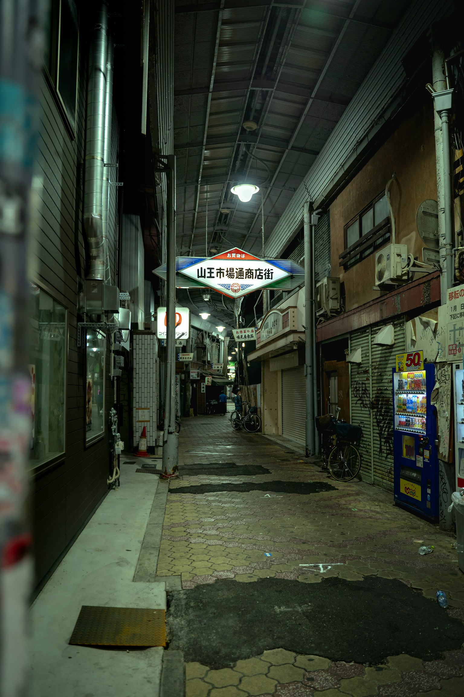 어두운 골목에 있는 간판과 자판기