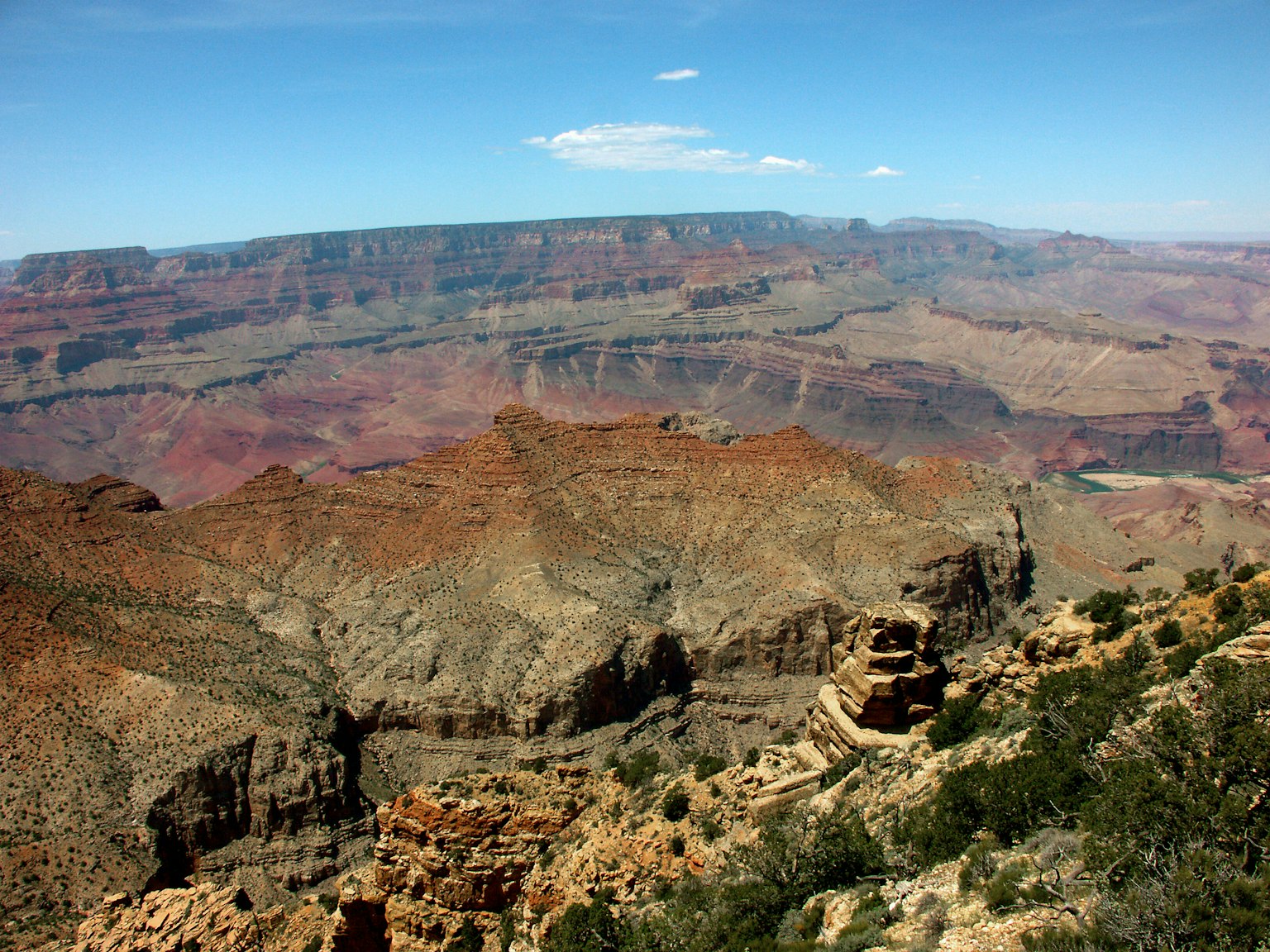 Pemandangan luas Grand Canyon dengan langit biru dan lapisan batu kemerahan