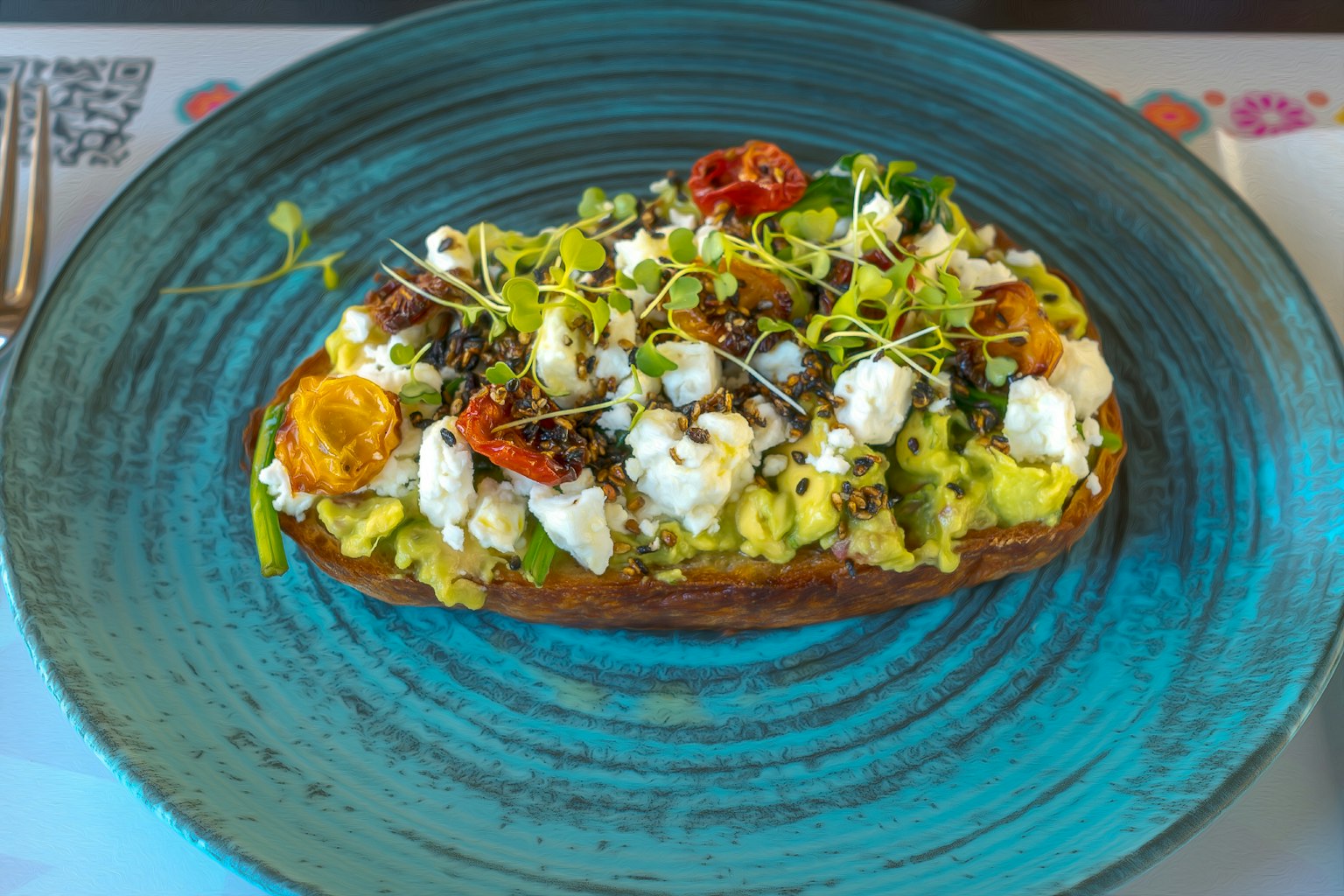 Toast con avocado guarnito con verdure tritate finemente e formaggio su un piatto blu