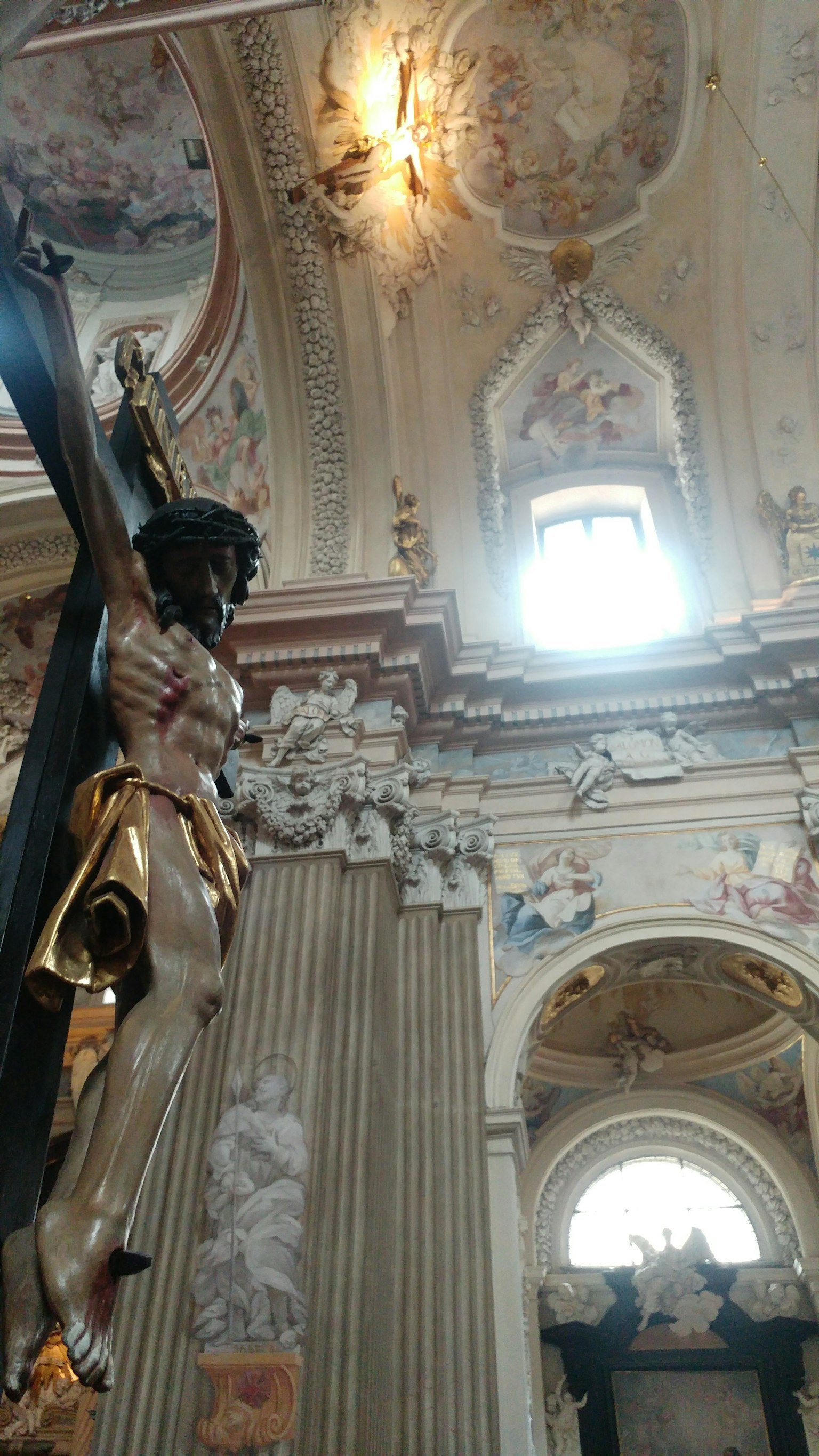 Interno di una chiesa con una statua dorata e decorazioni di soffitto ornate