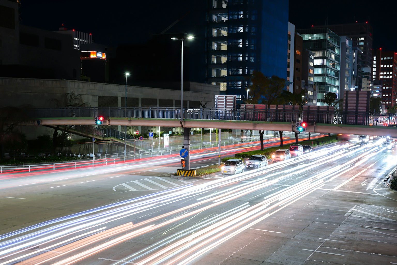 夜晚城市交叉口的交通灯和照明汽车