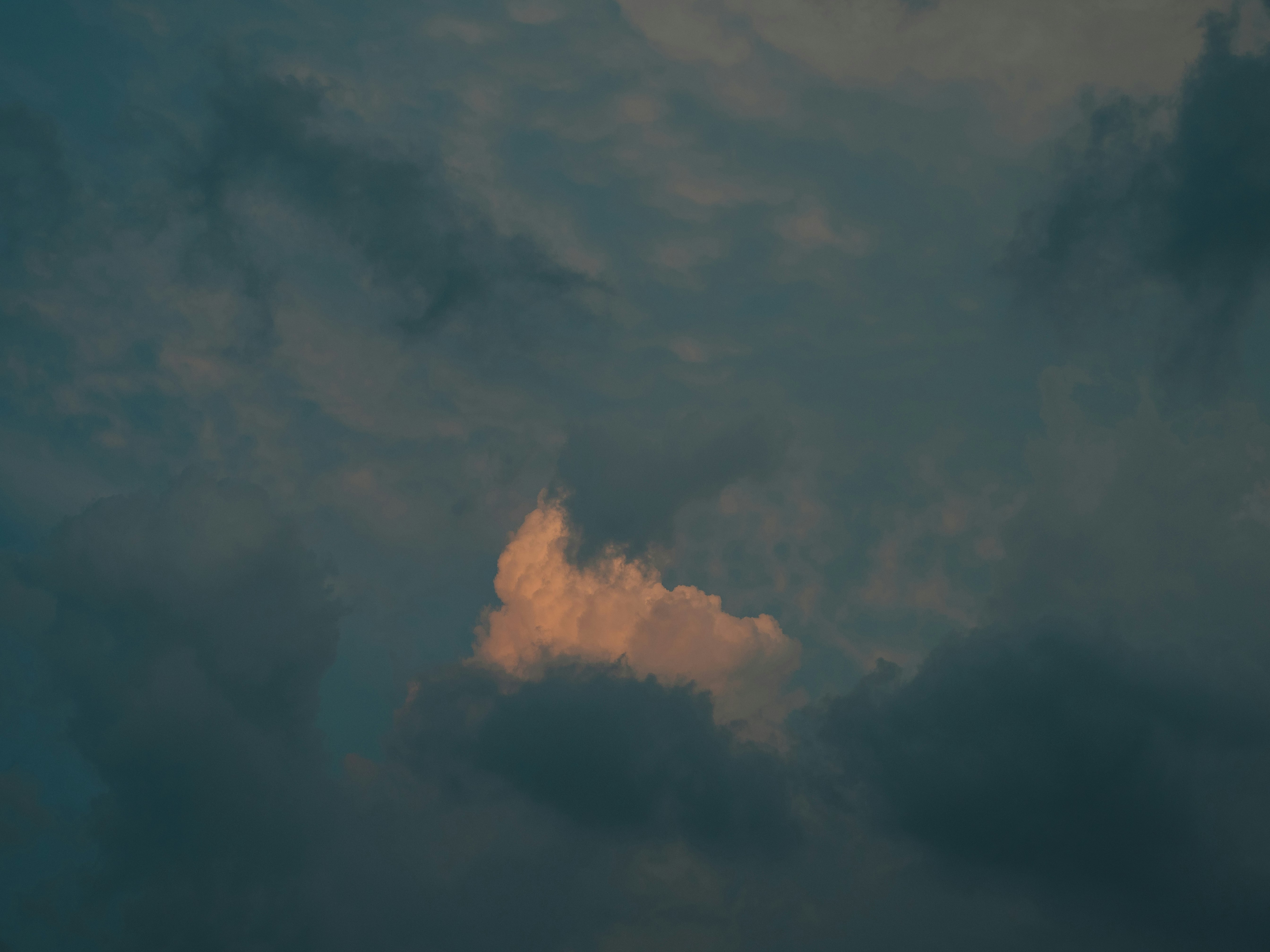 雲の隙間から差し込む光と煙のような雲の筋