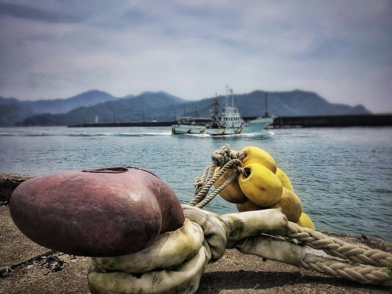 伊勢湾の港でロープと漁船を見下ろす風景