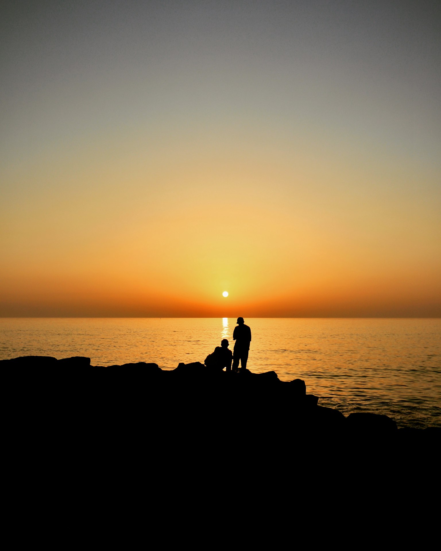 Silhouette của mọi người trên bờ biển lúc hoàng hôn