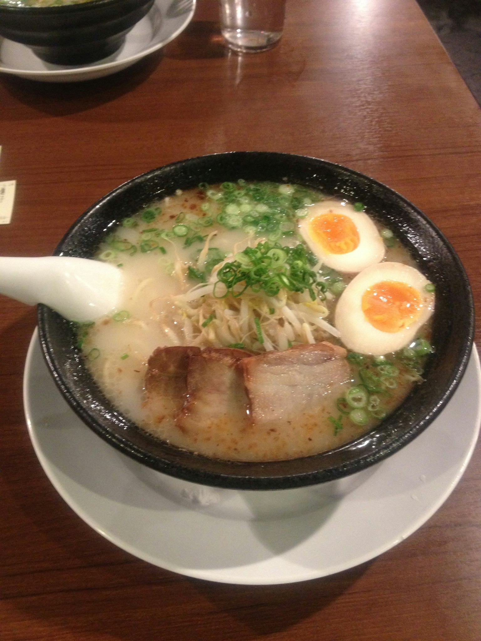Eine Schüssel Ramen mit Schweinefleischscheiben und weichgekochten Eiern garniert mit Frühlingszwiebeln