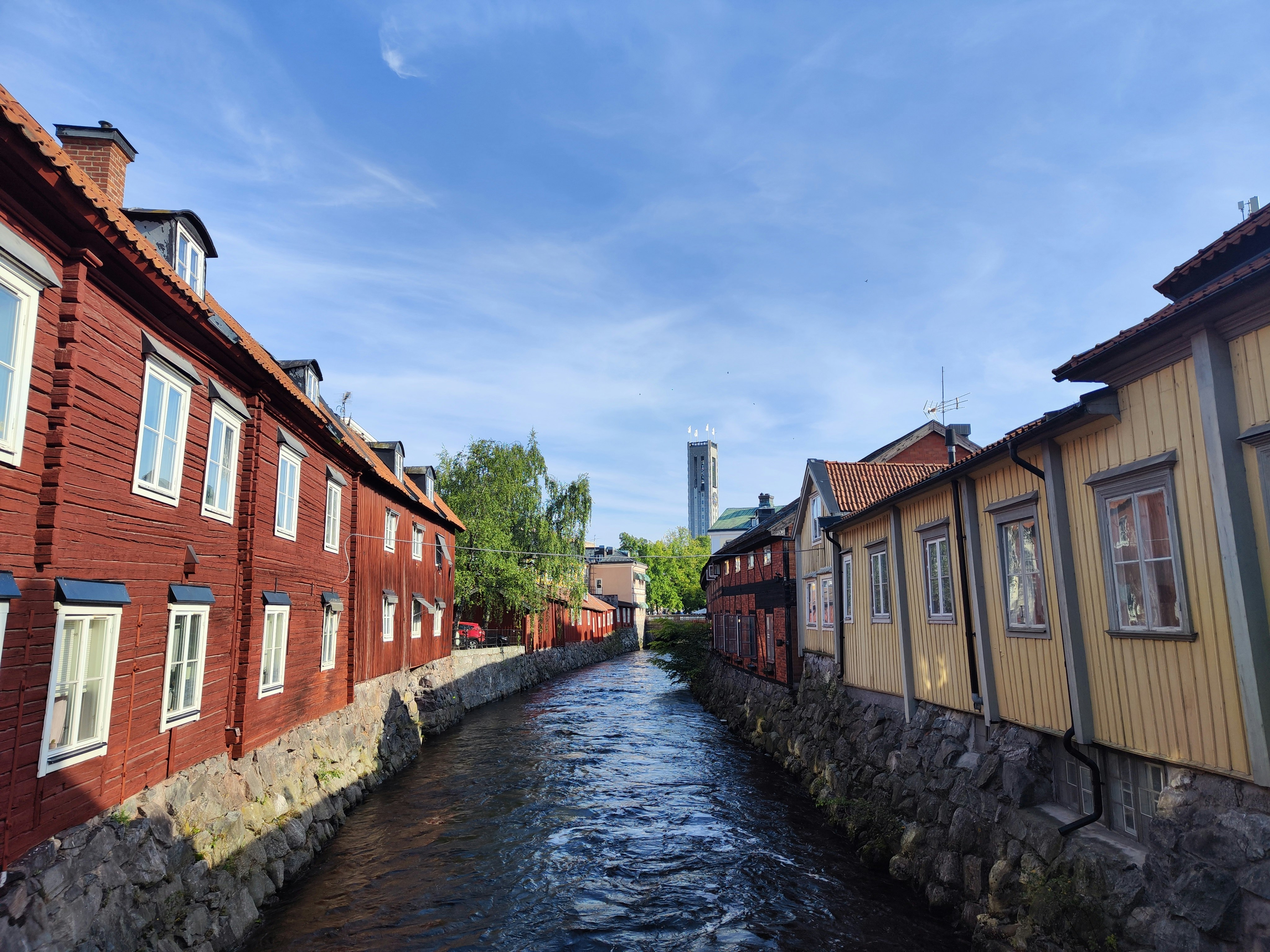 row of red brick and wooden houses along a stone-lined lane