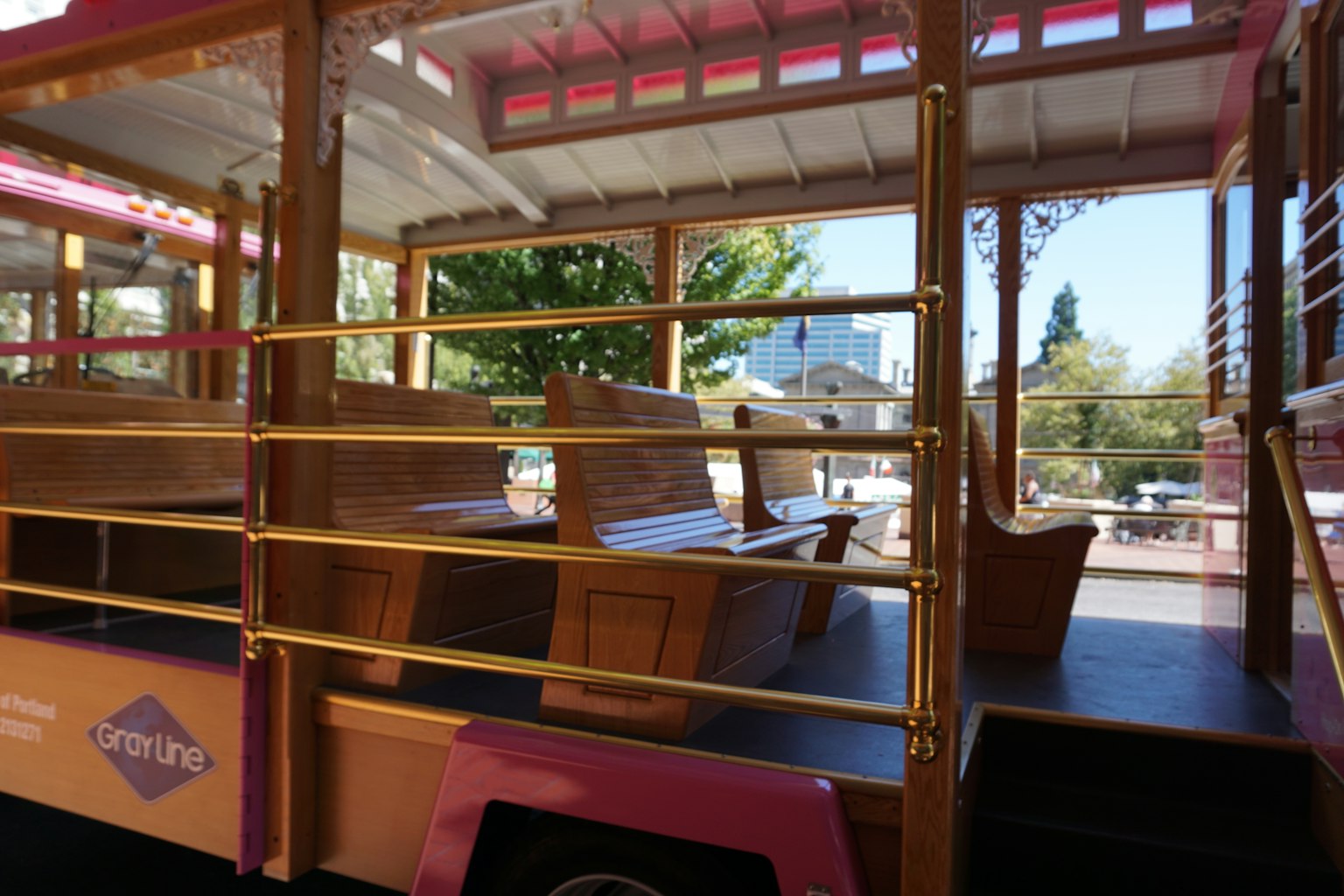 Colorful trolley interior featuring wooden benches and gold railings