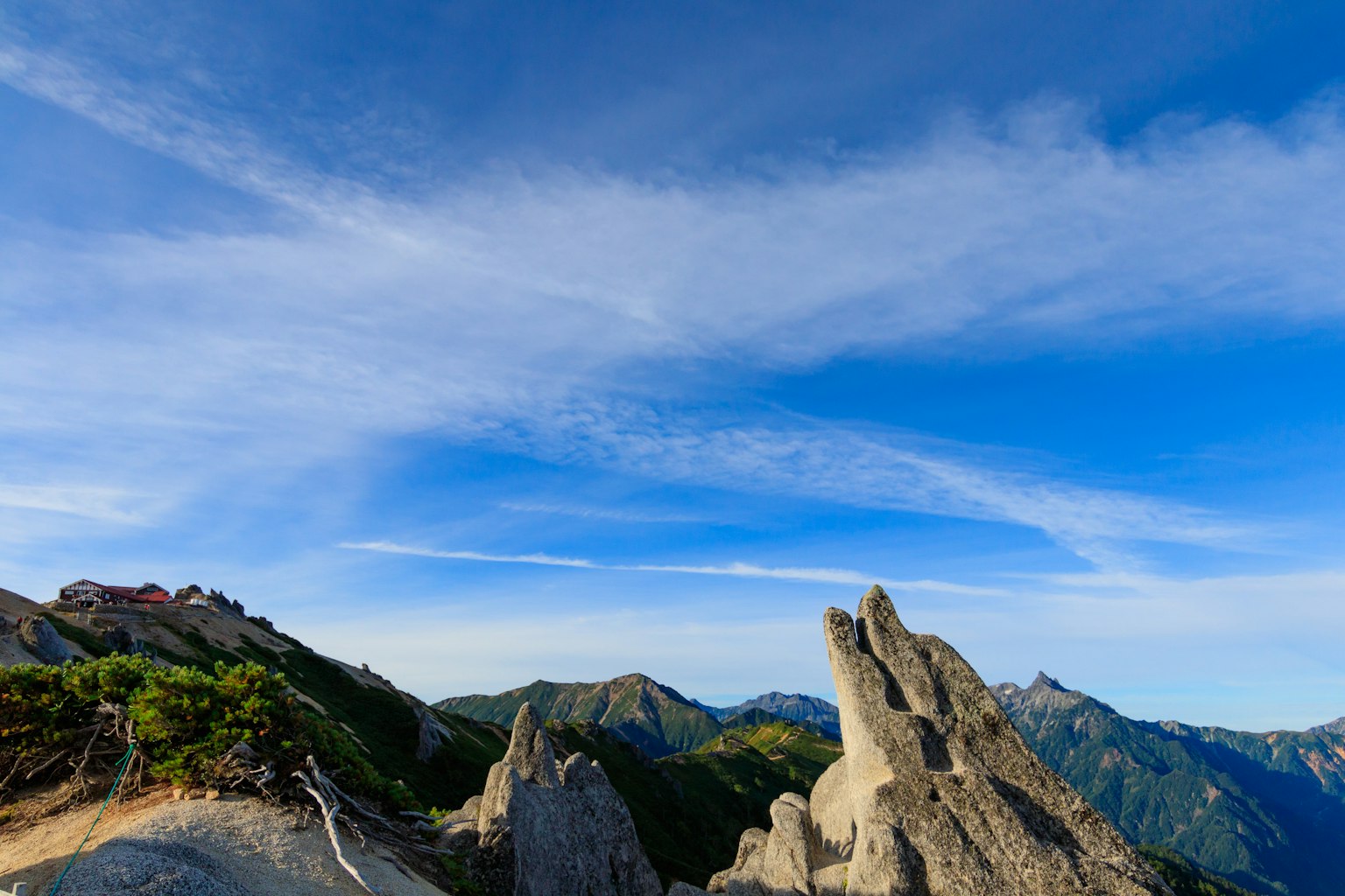 Vista escénica de montañas bajo un cielo azul con formaciones rocosas distintivas