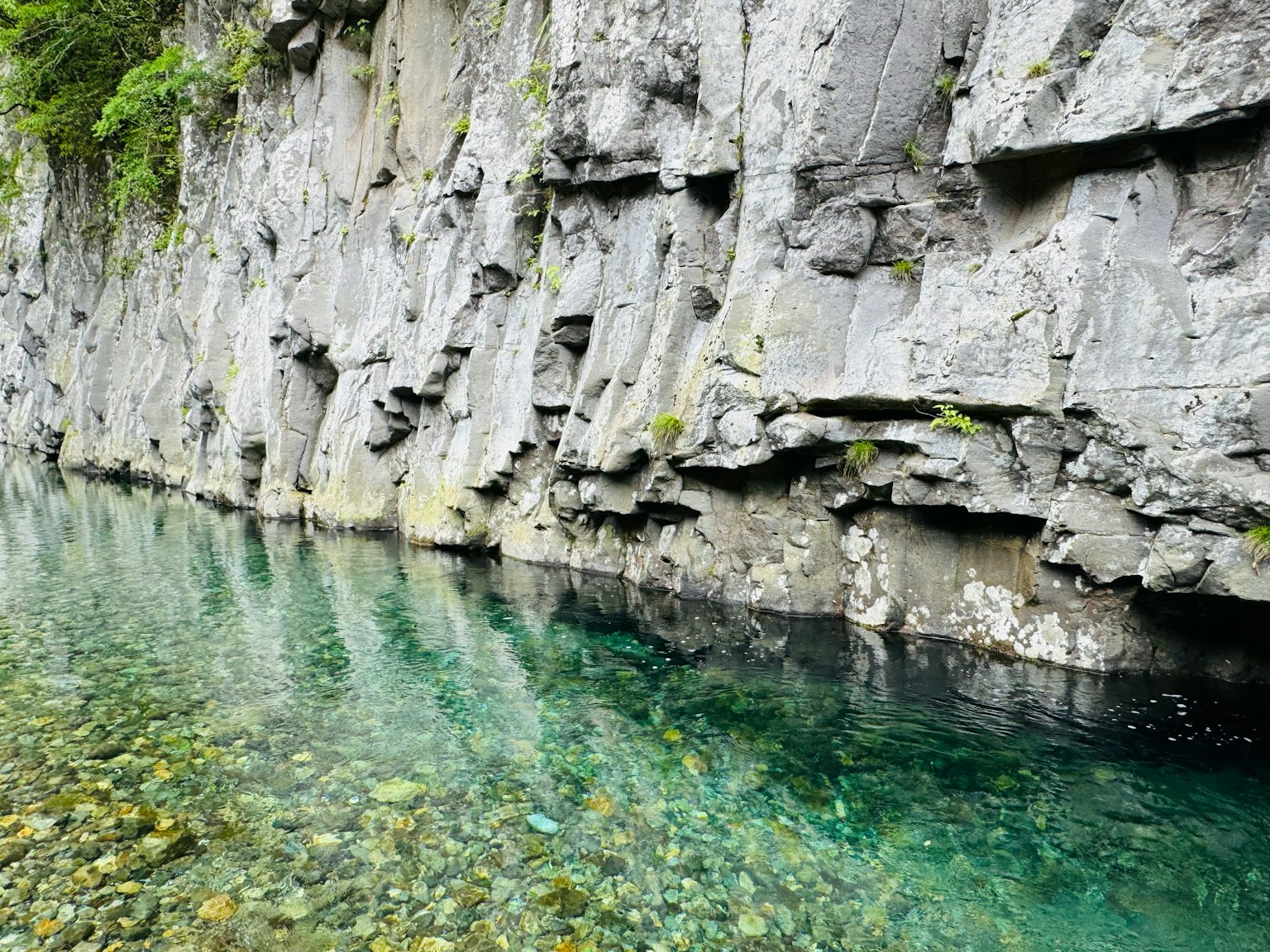 清澈的水和灰色岩壁的自然風景