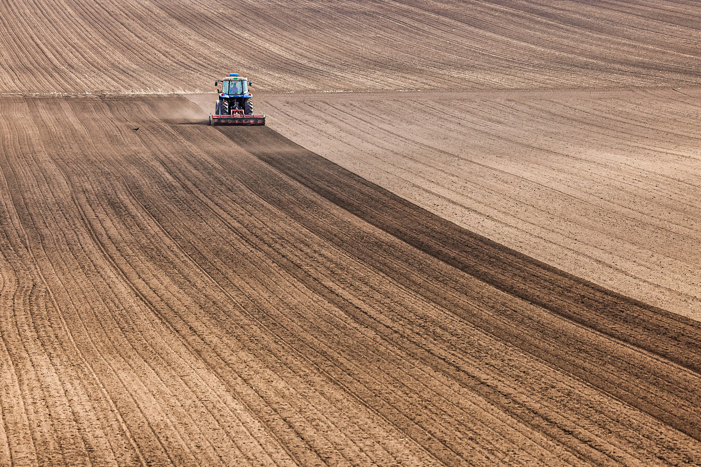 tractor driving across a vast field