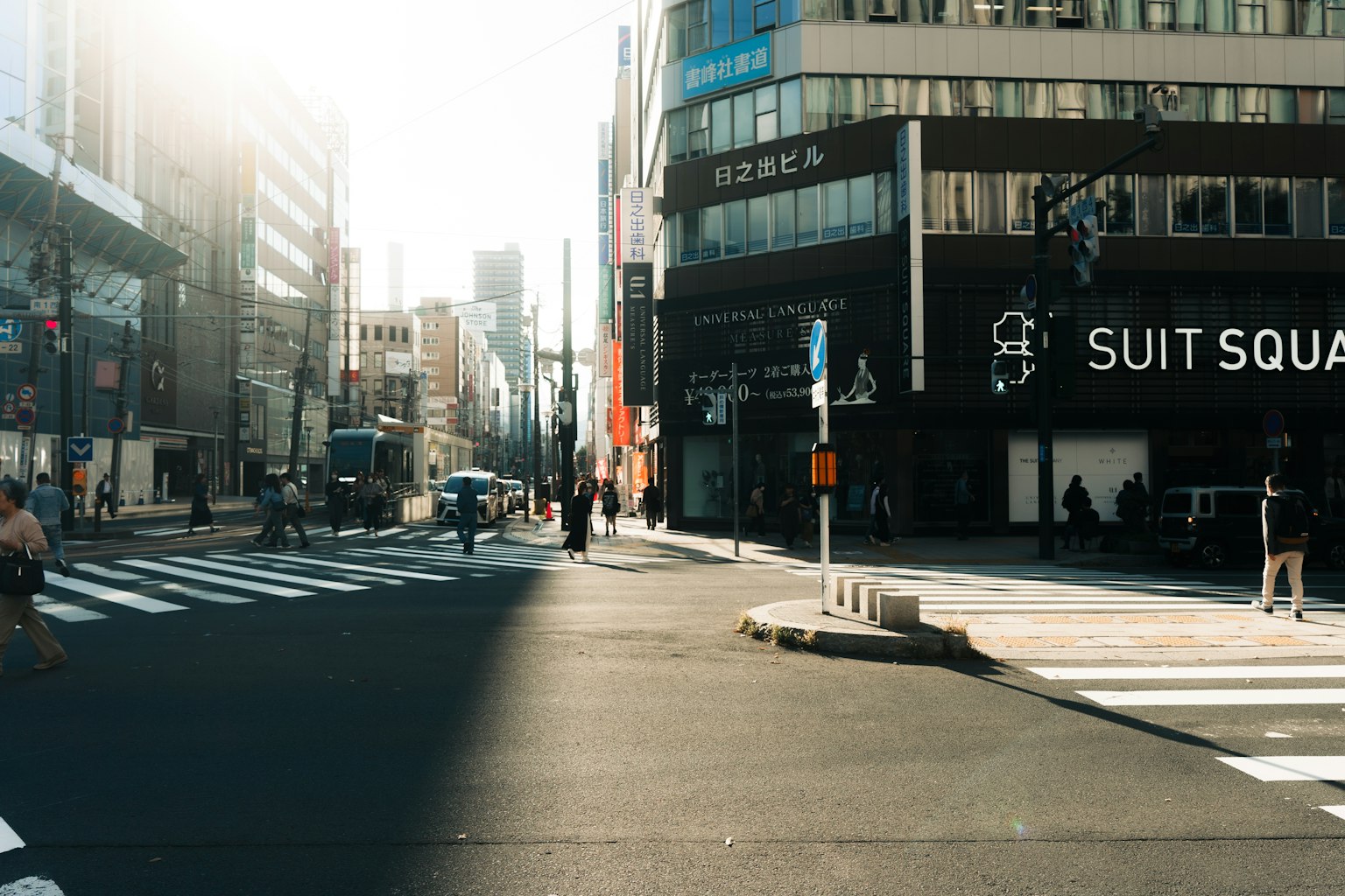 Intersección urbana con personas y vehículos bajo la luz brillante