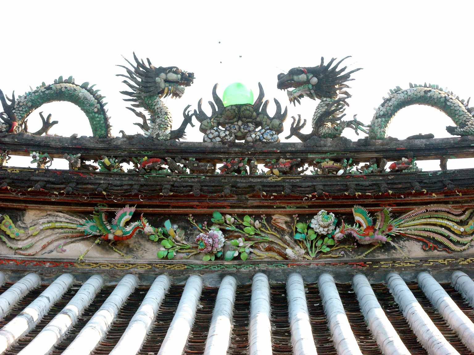 Dos dragones y tallas decorativas de plantas en un techo
