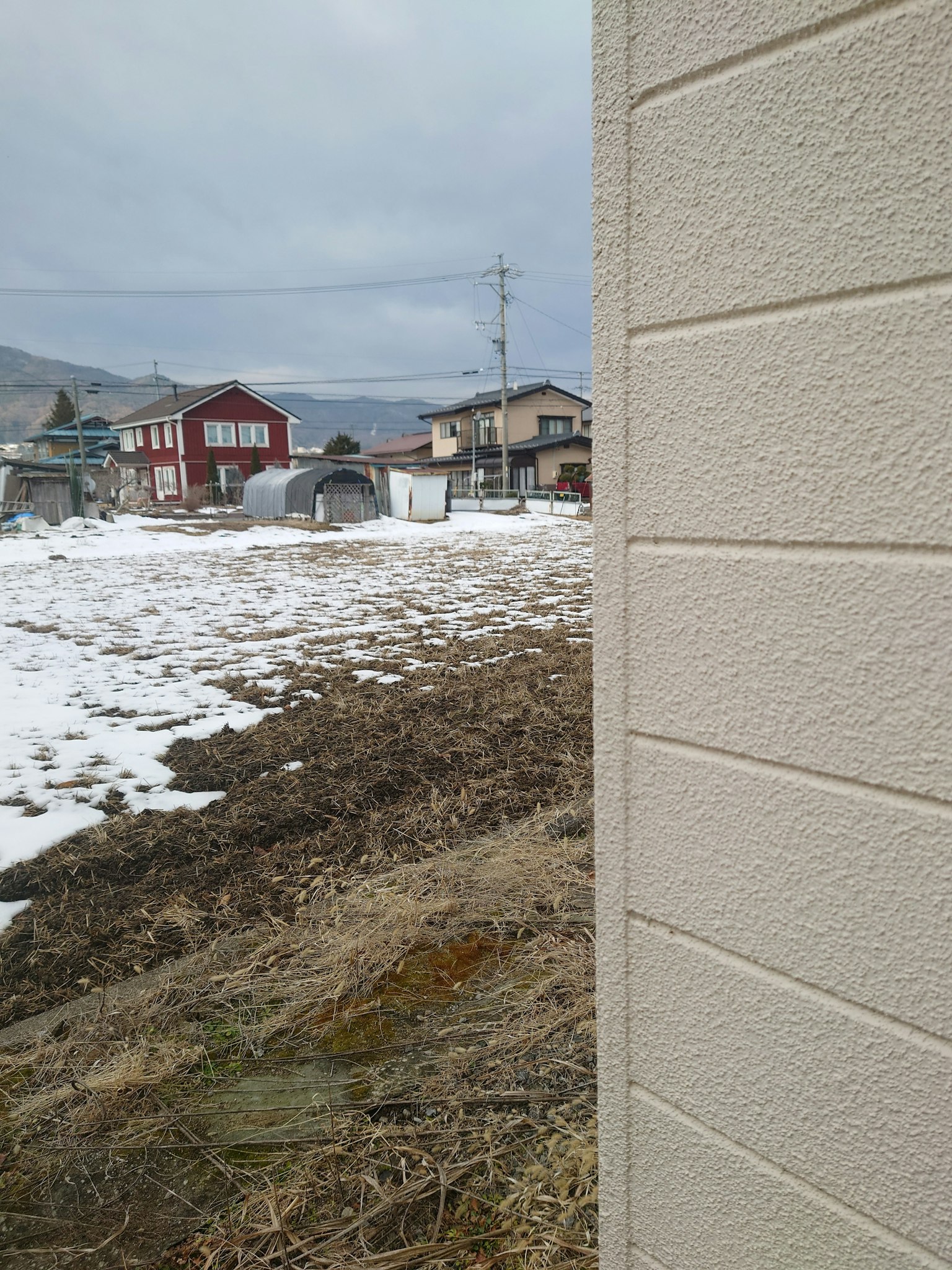 Rural landscape showing snow and houses in the background