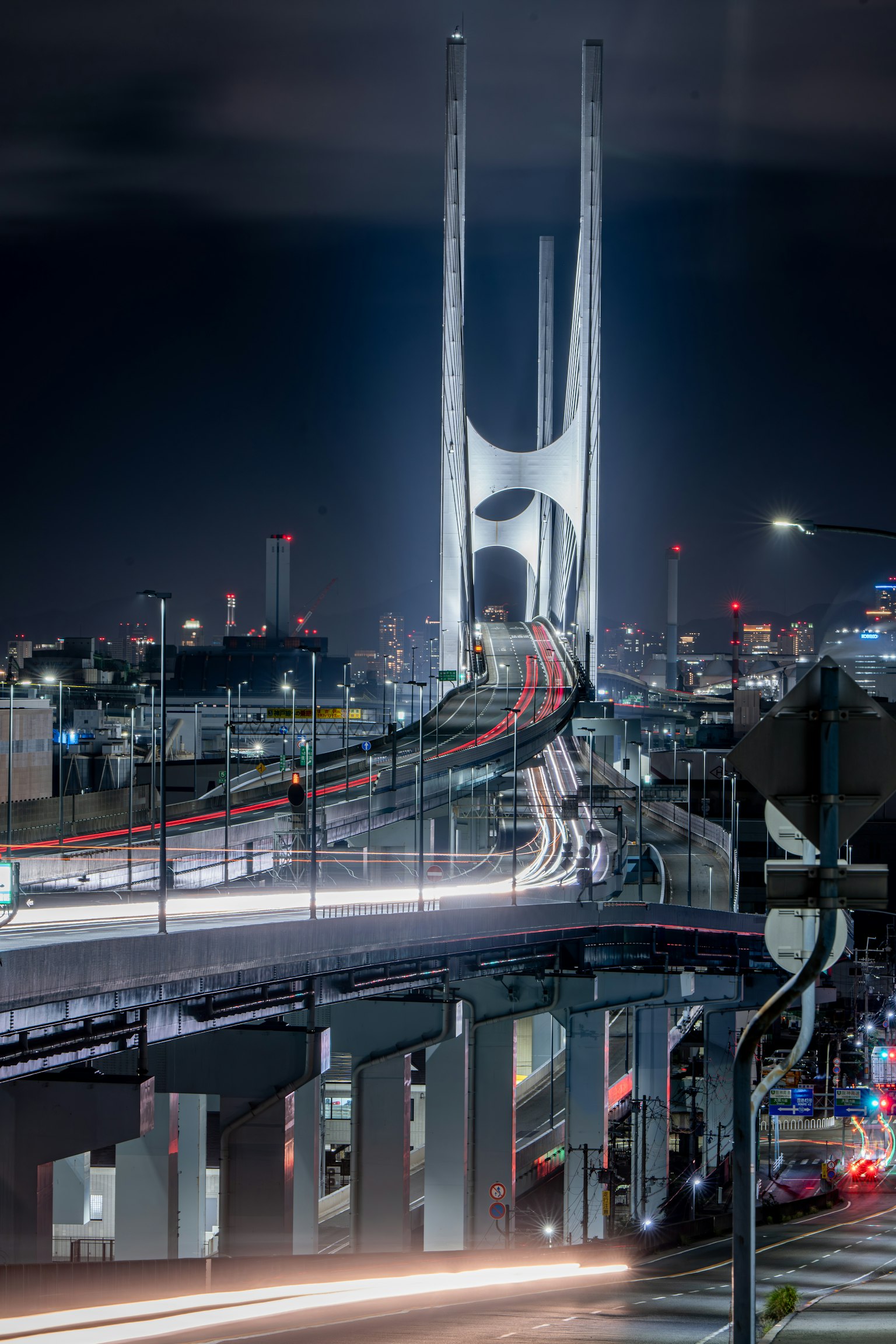 Ponte dal design innovativo che si erge sul paesaggio urbano di notte con luci di auto che scorrono