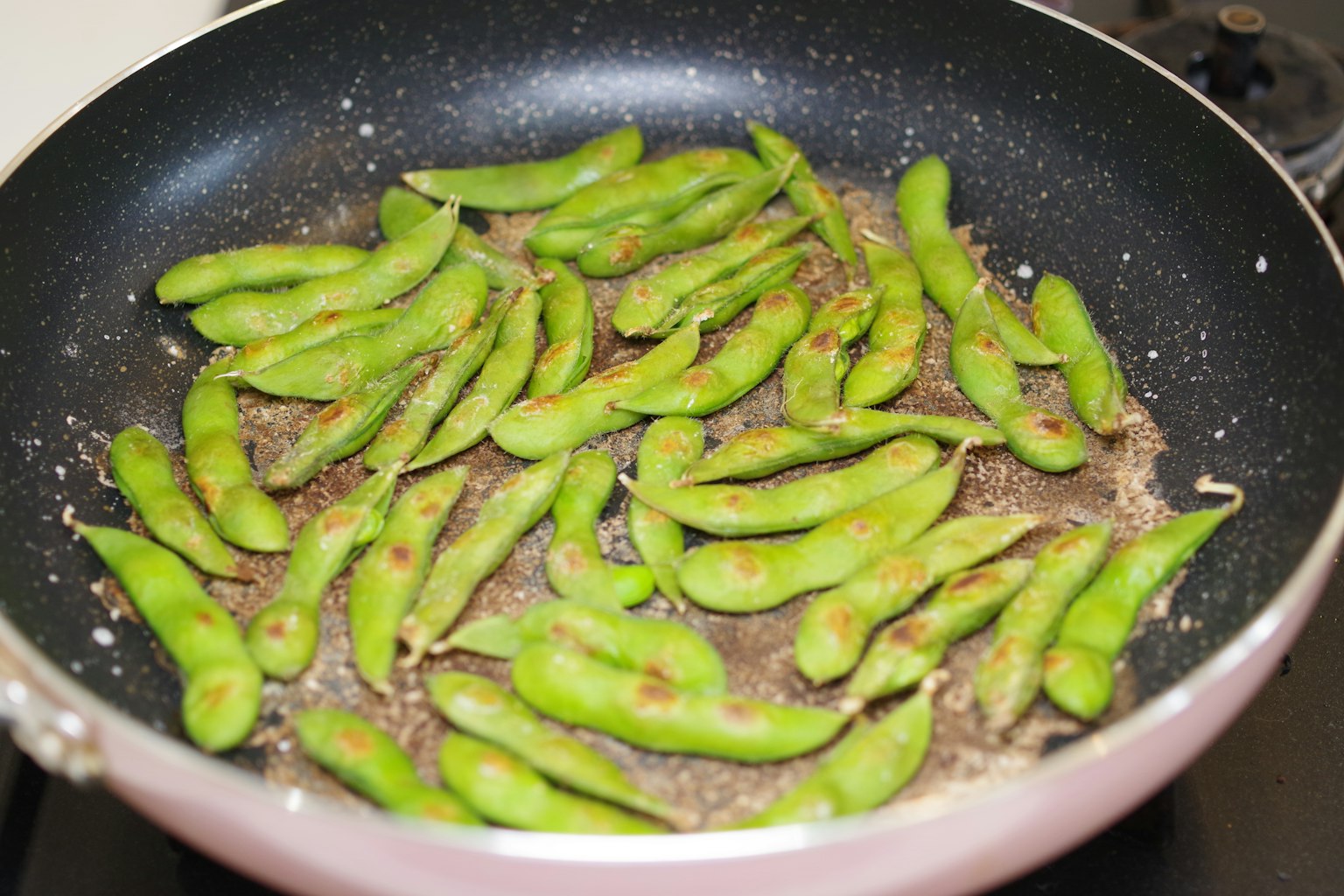 Frijoles edamame verdes cocinados en una sartén