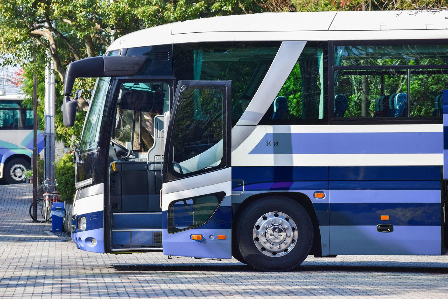 Autobús azul y blanco estacionado con puerta abierta para pasajeros