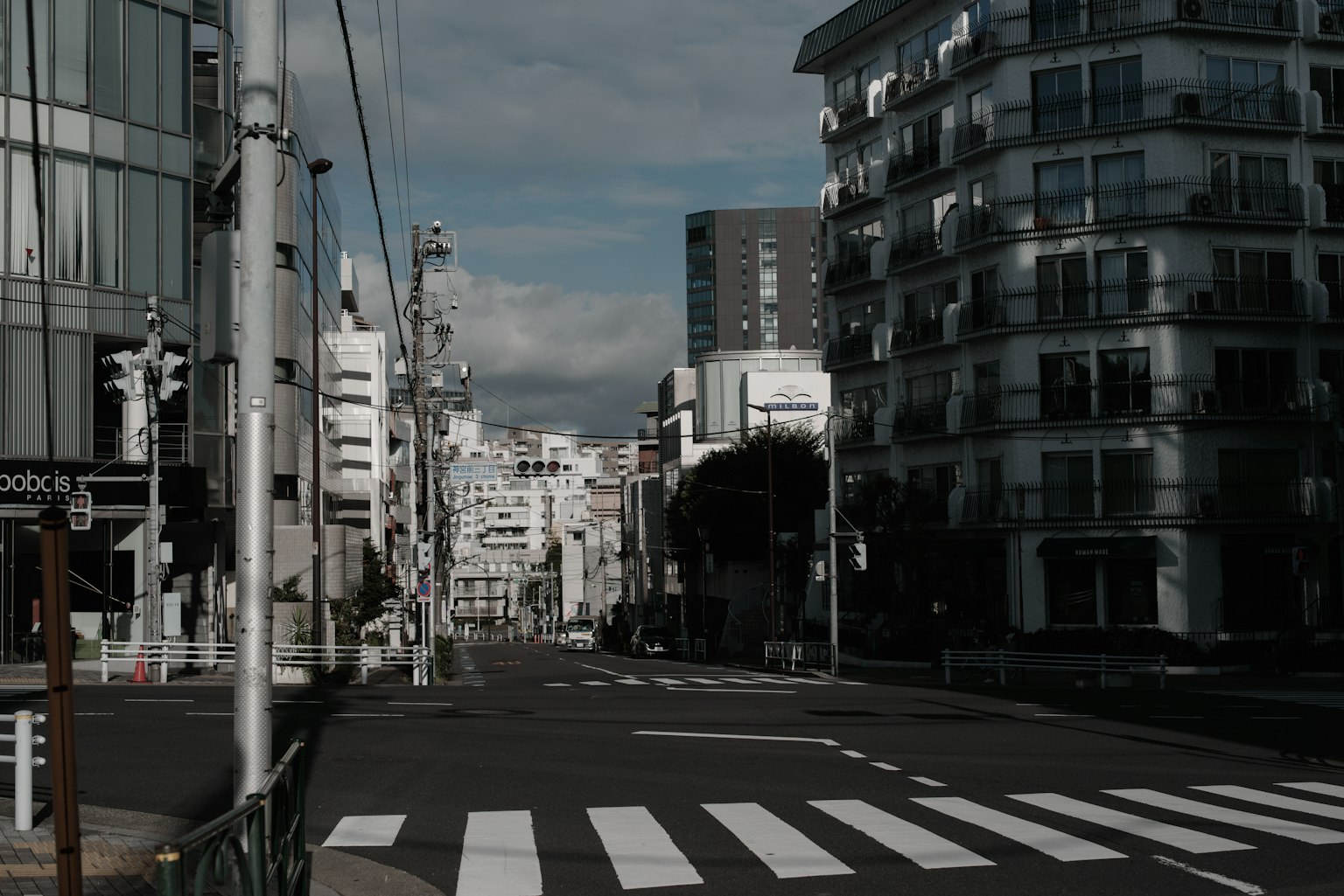Scène de rue urbaine avec des bâtiments et un ciel nuageux