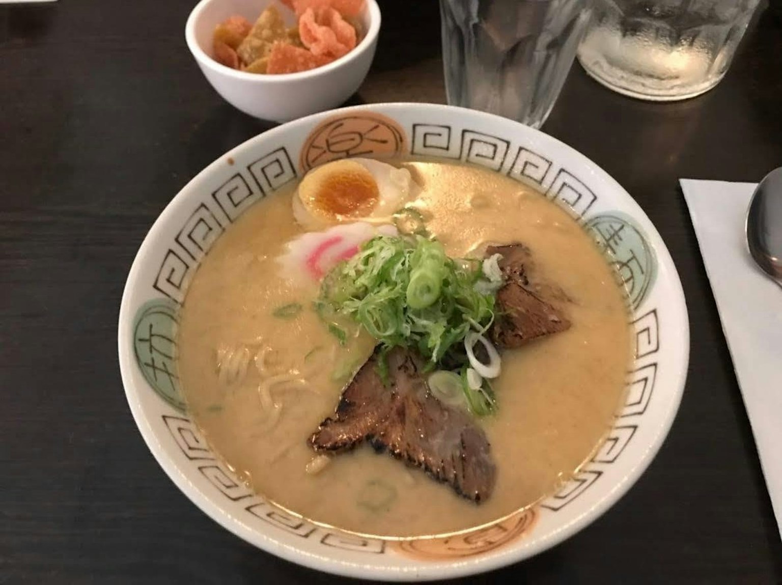 Mangkok ramen tonkotsu dengan chashu, telur setengah matang, dan daun bawang