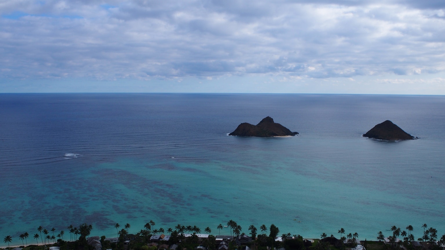 Scenic view of blue ocean with two small islands