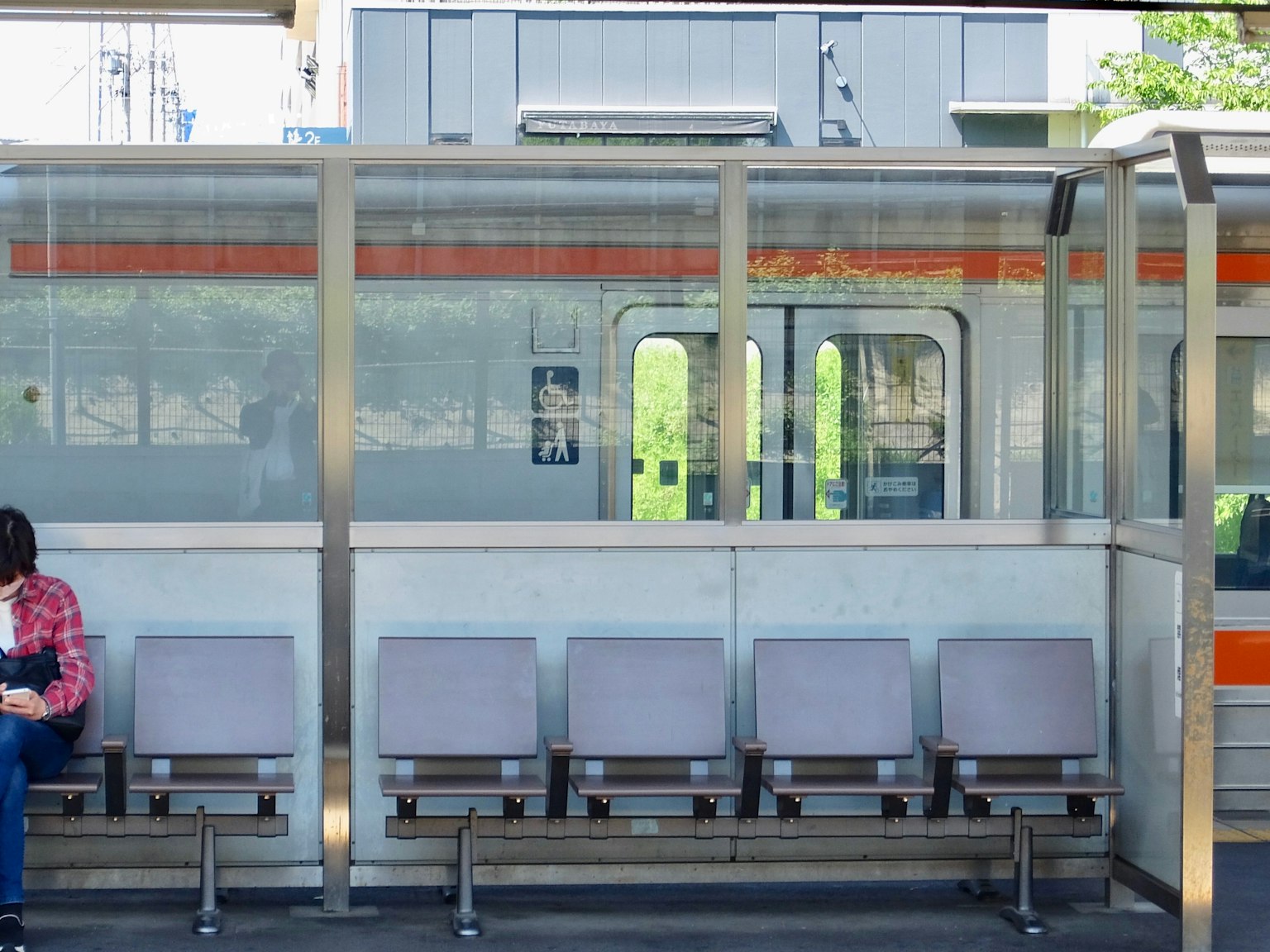 一個人坐在火車站候車區，旁邊有空座位