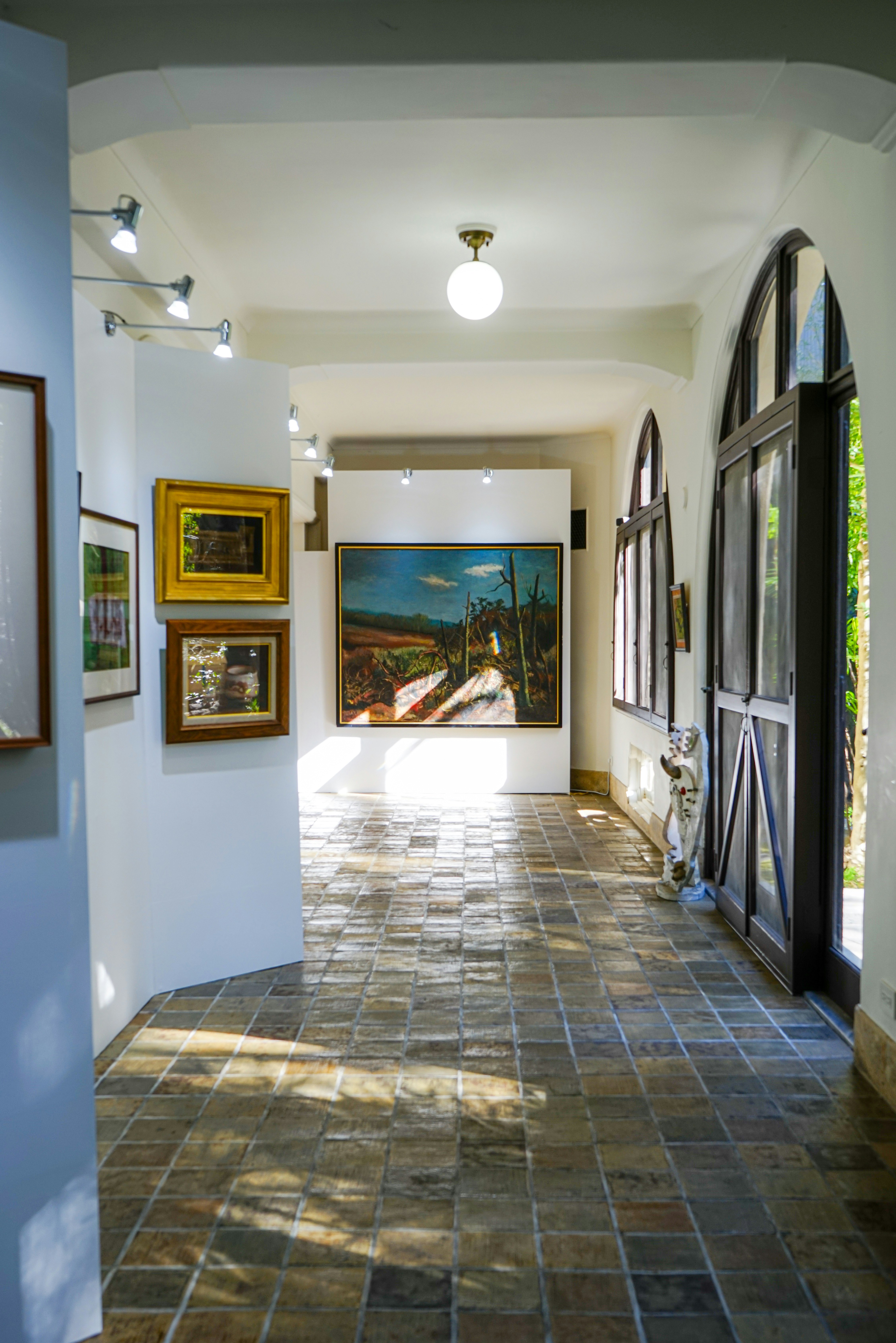 アートギャラリーの廊下に展示された絵画とタイルの床