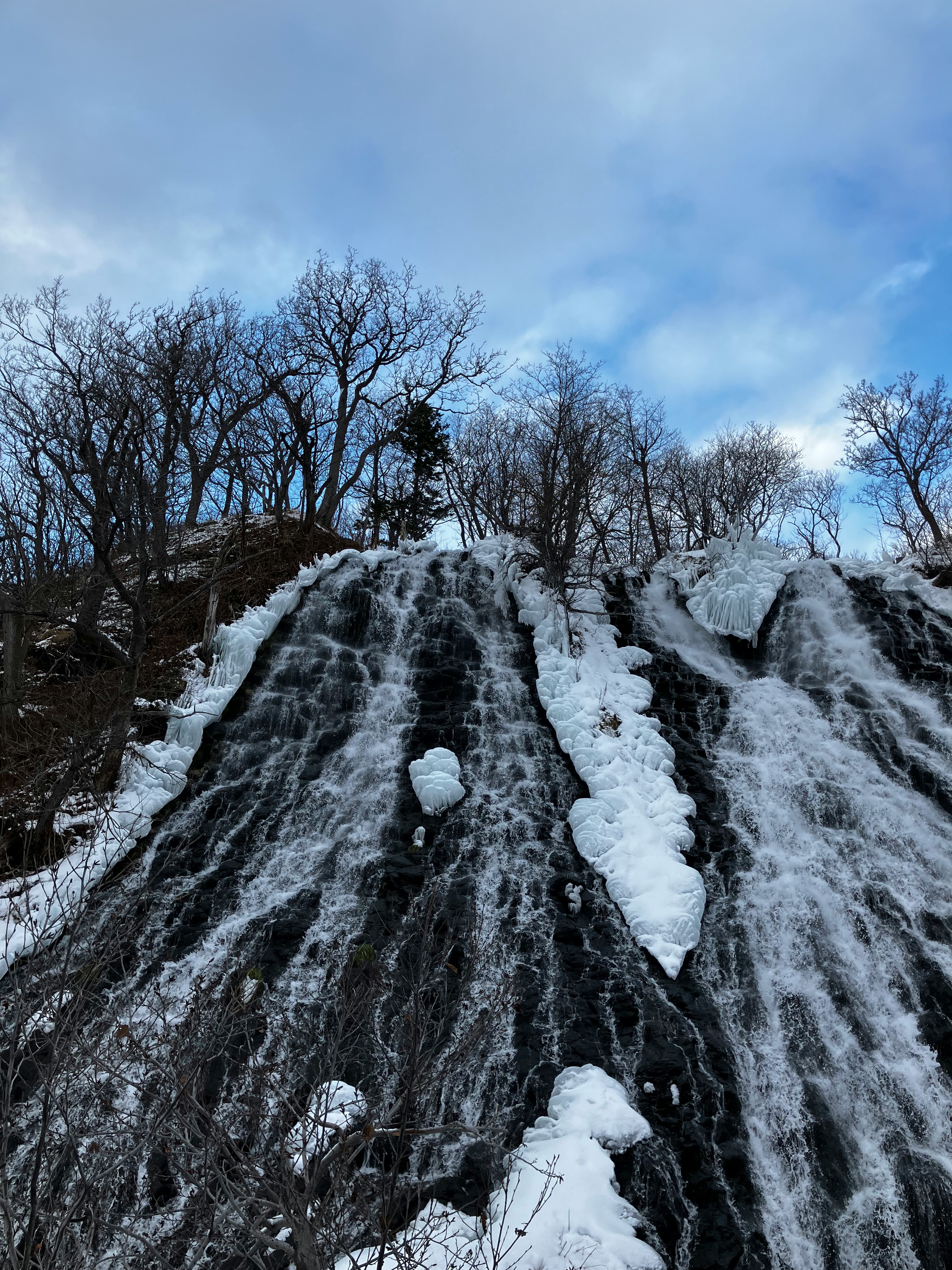 雪の積もった岩肌の滝