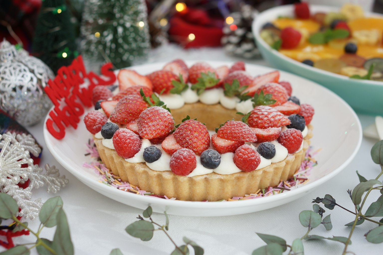 Une tarte aux baies festive décorée de fraises et de myrtilles sur une table de fête