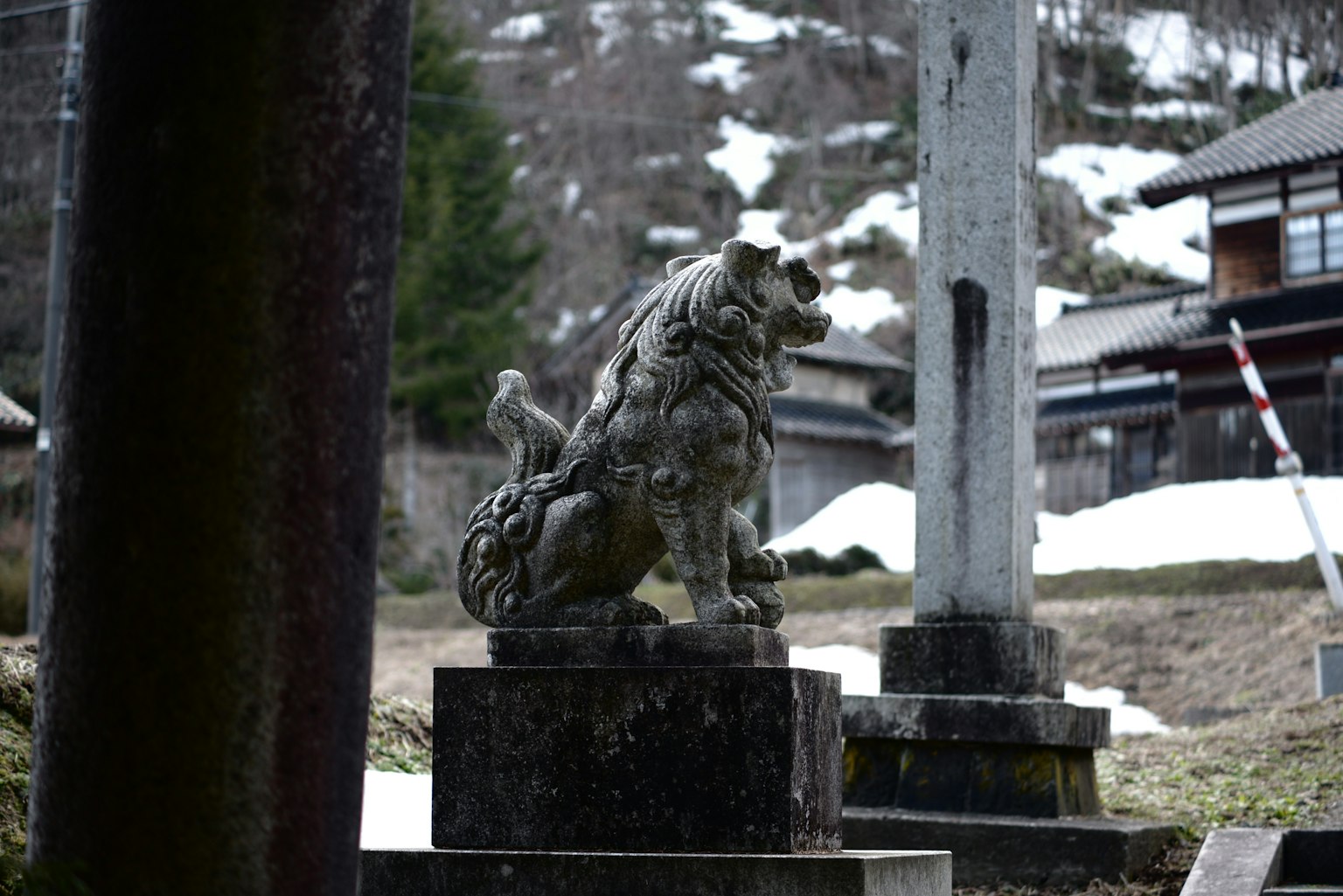 Statua in pietra di un leone custode in un paesaggio innevato