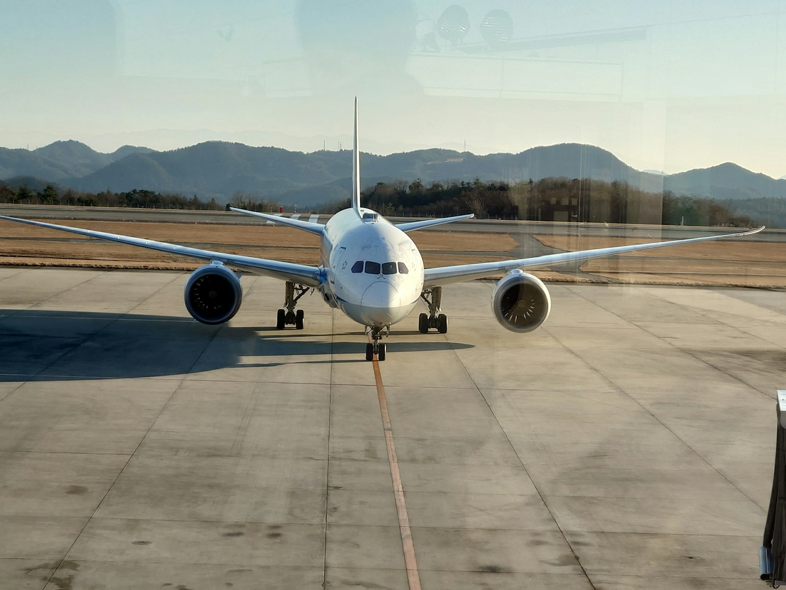 Boeing 787 on the runway with mountains in the background