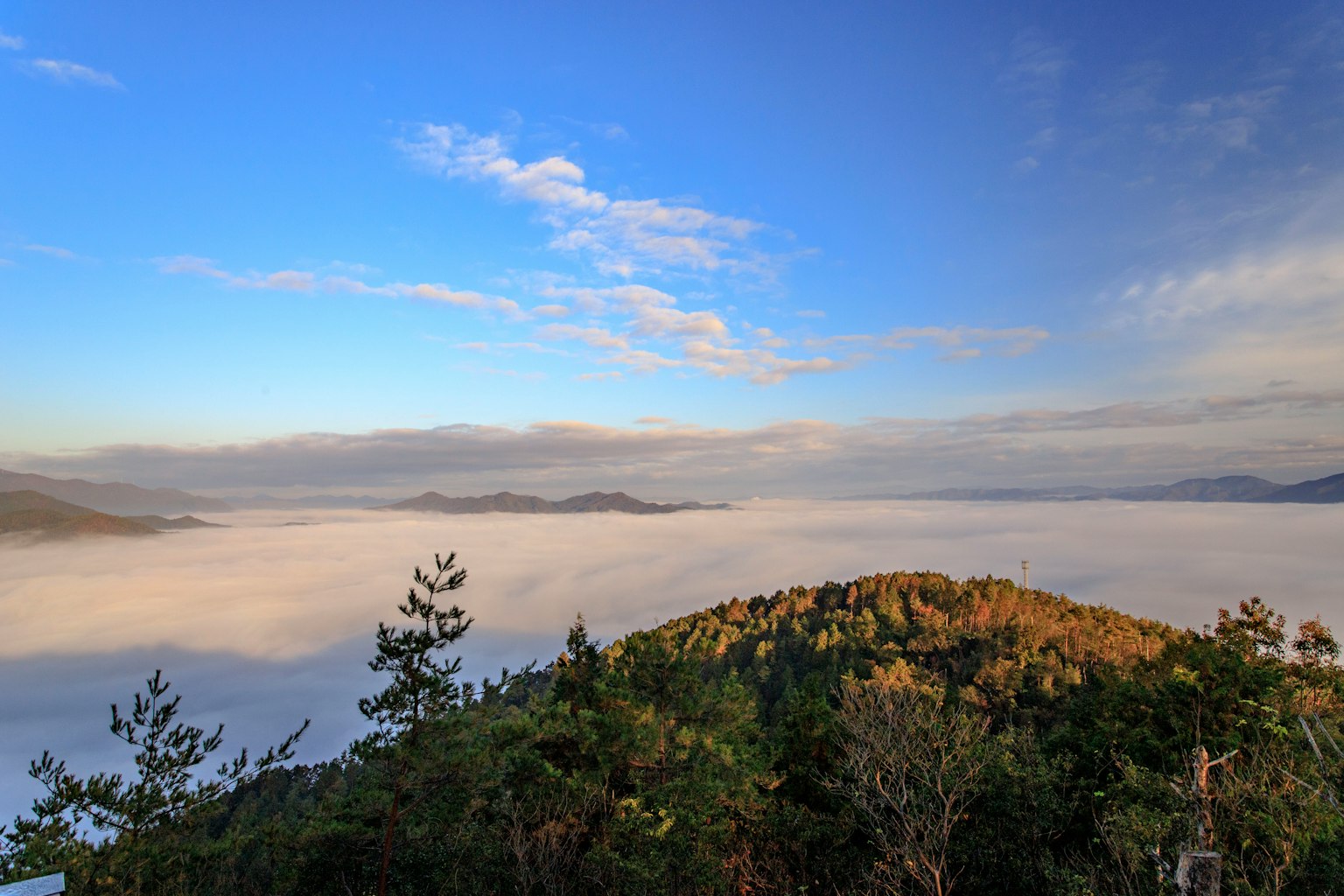 Mountain landscape covered in fog with a blue sky