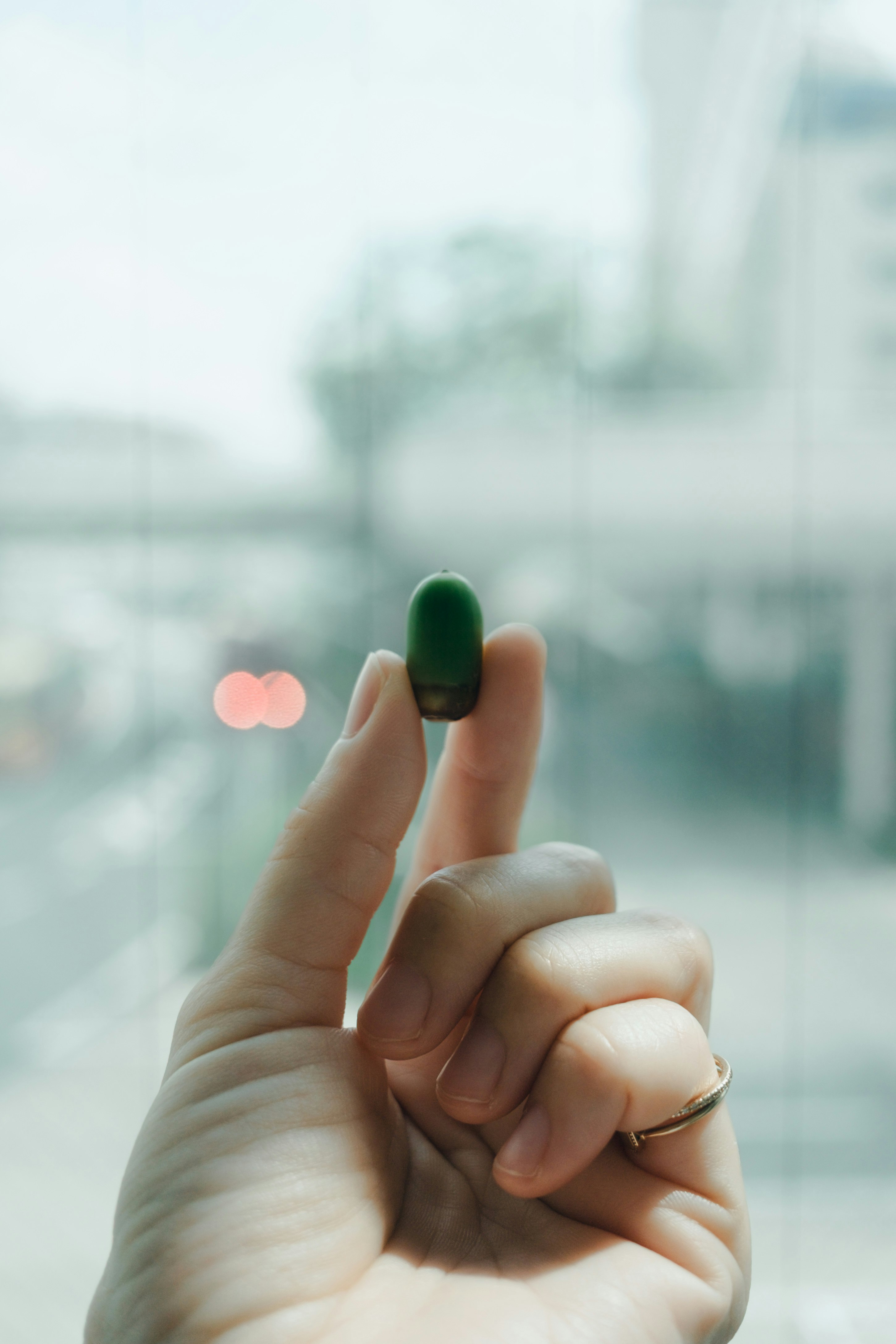 close-up of a hand holding a green nail tip