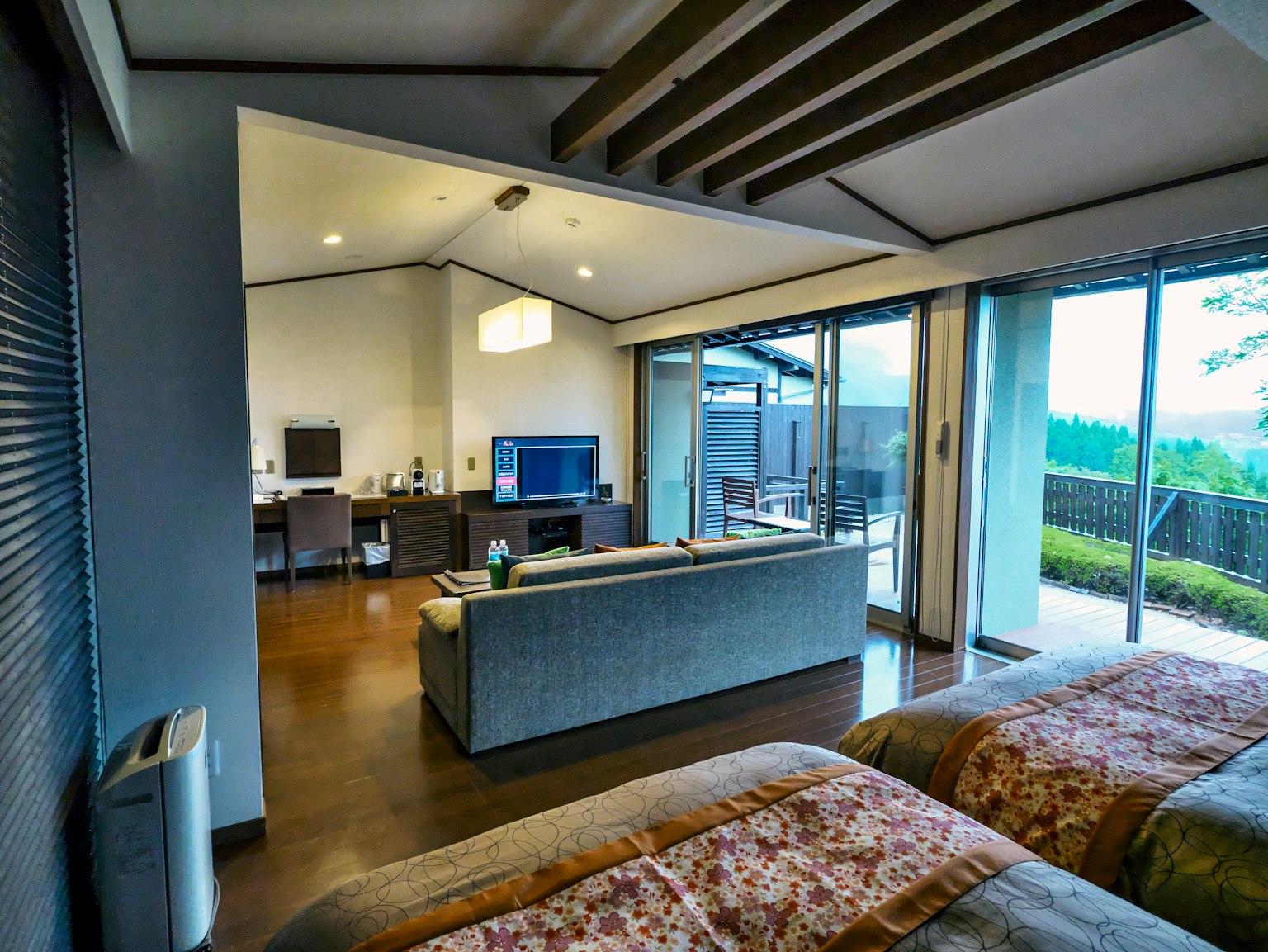 Modern guest room interior with two beds, living space, and beautiful view through windows
