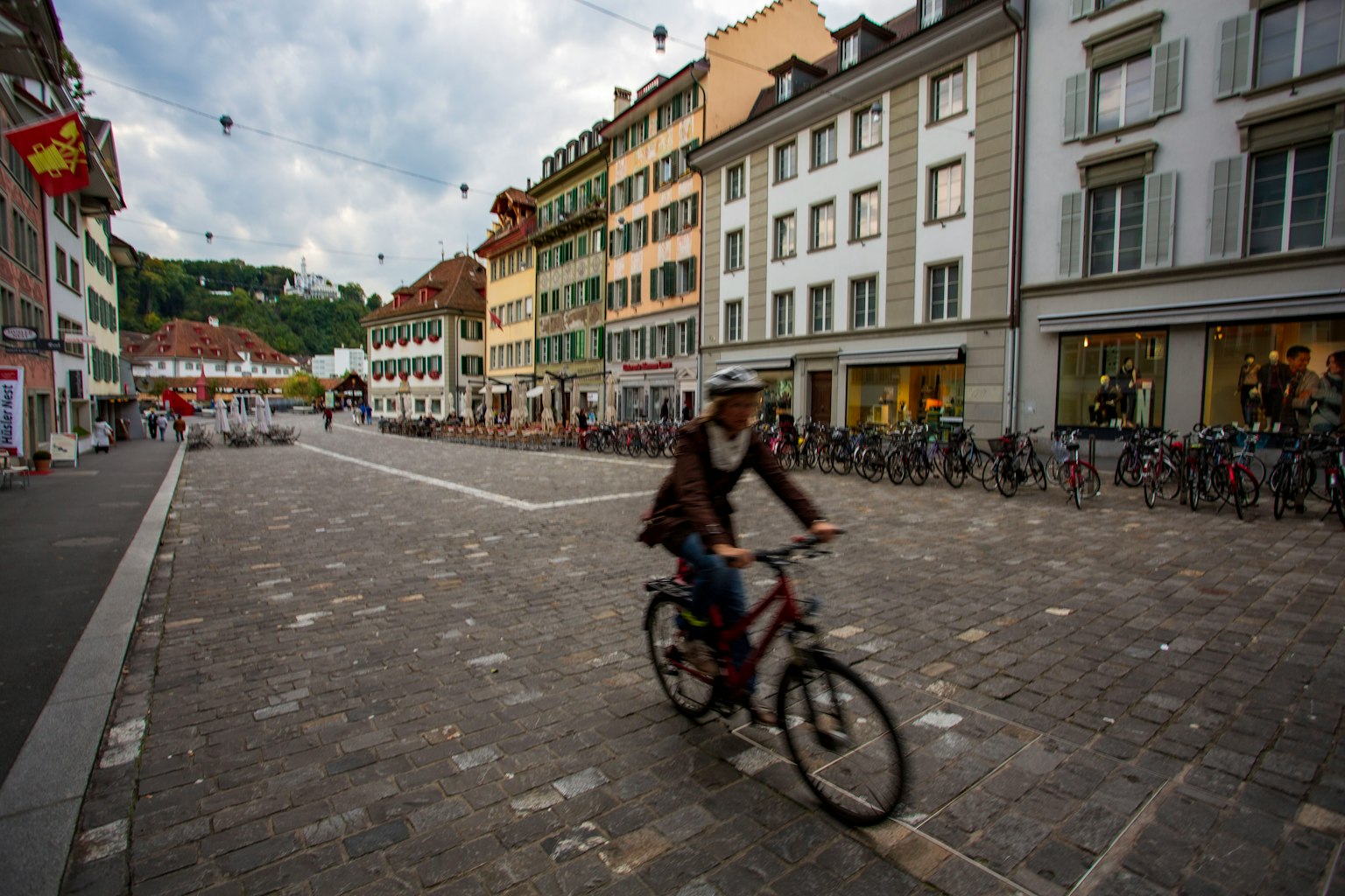Un ciclista che pedala su una strada acciottolata a Lucerna